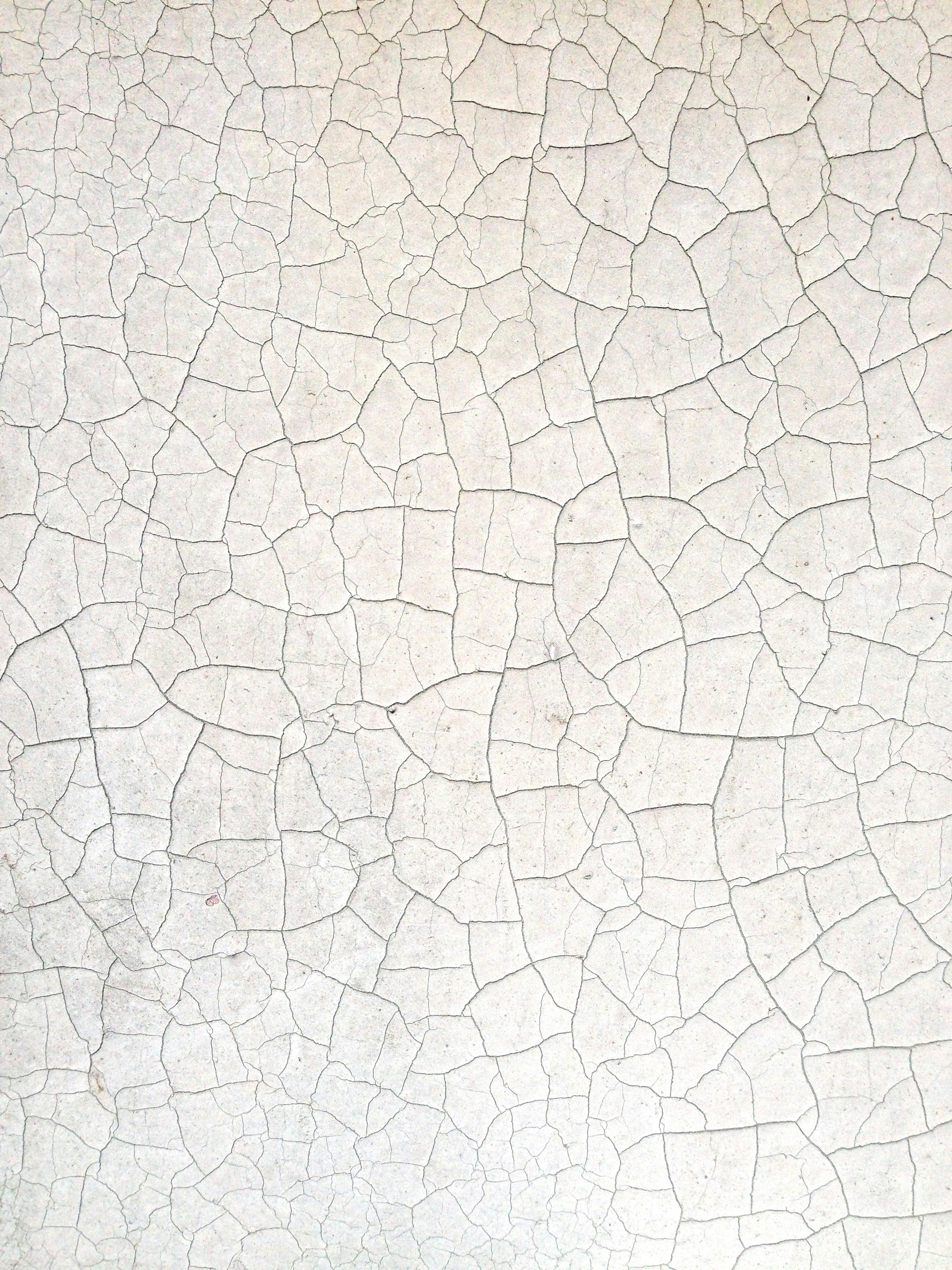 A Close Up Of A White Wall With Cracks In It