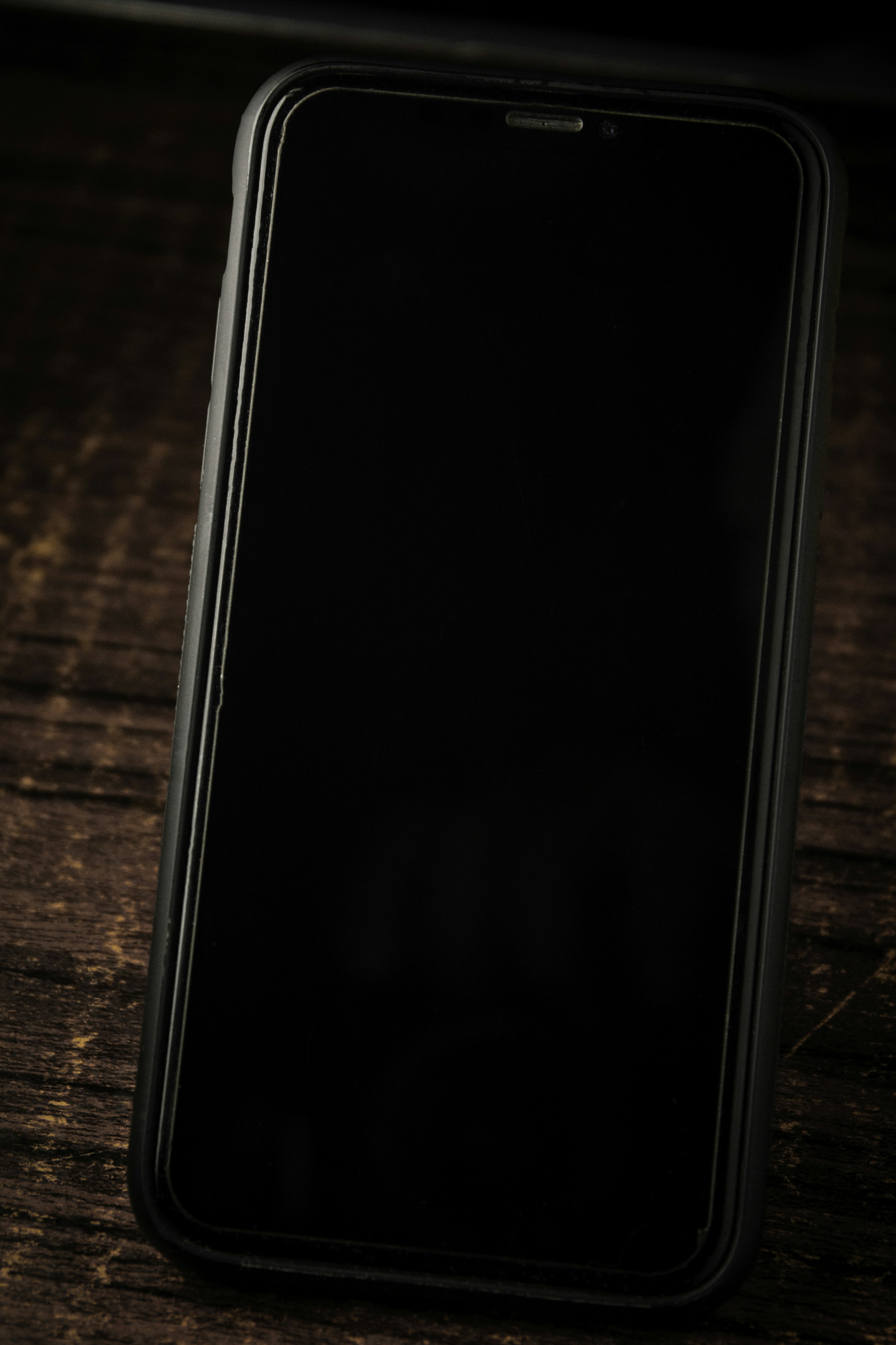 黑色手机静立于木板桌上