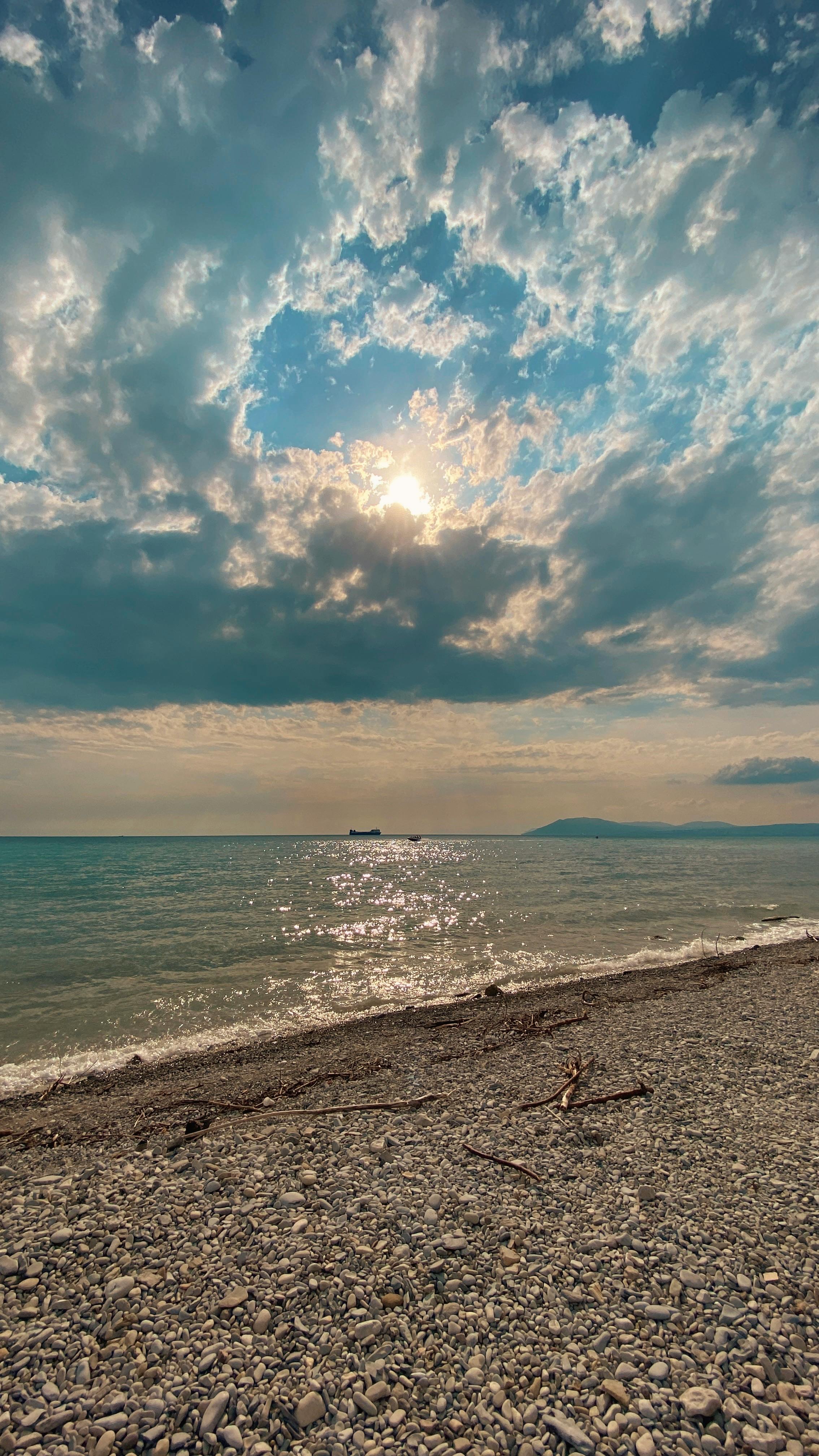 A Tranquil Pebble Beach Scene With Gentle Waves Under A Vibrant Sunrise Sky. HD mobile wallpaper
