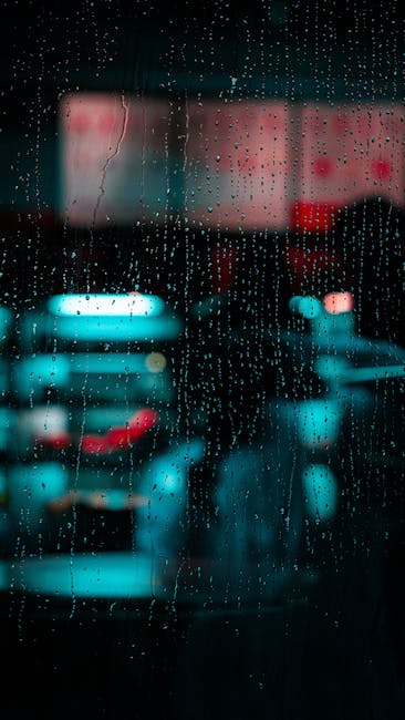 Raindrops On A Window With Blurred City Lights In Dubai, Creating A Moody Urban Night Scene. wallpaper preview