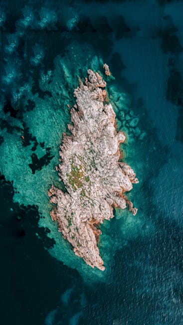 Scenic Aerial View Of A Rocky Island Surrounded By Turquoise Ocean Water Near Conway, SC. wallpaper preview