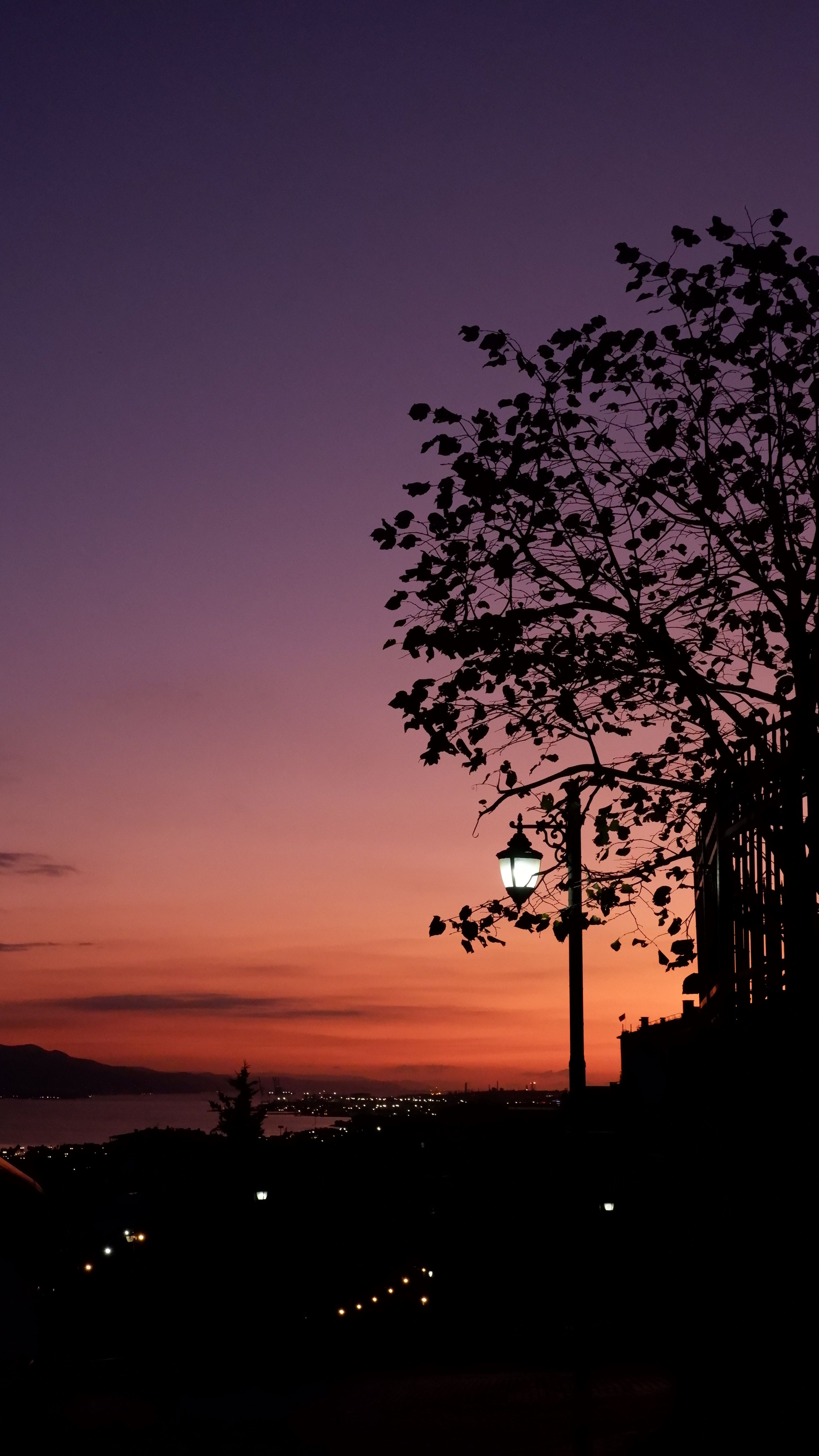 A Breathtaking Sunset Painting The Sky In Vivid Hues Over A City Silhouette. HD mobile wallpaper