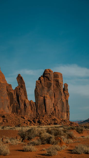 Stunning Red Rock Formations Under A Clear Sky In Arizona, Capturing The Rugged Beauty Of Nature.