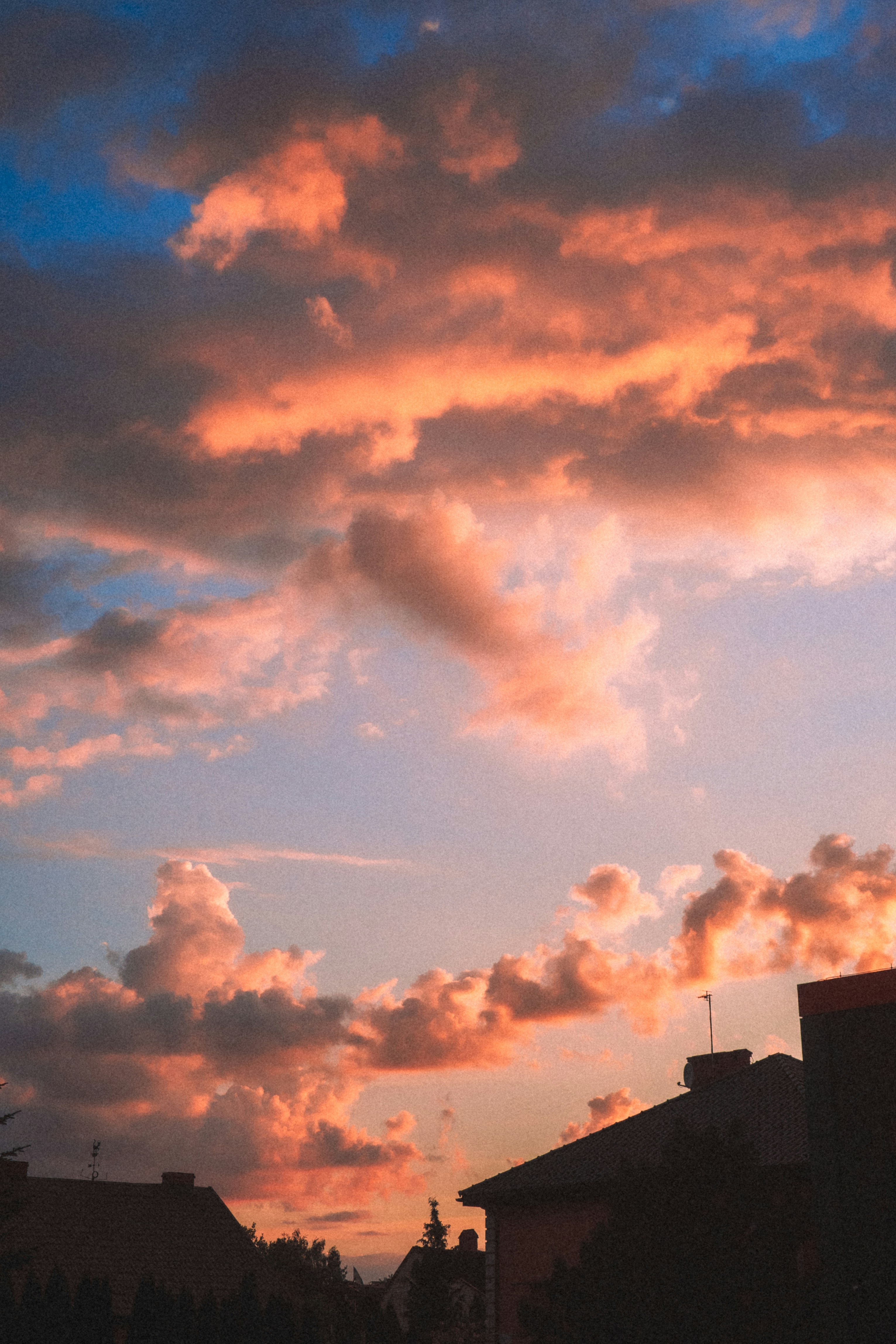 Dramatic Sunset Clouds Over Silhouetted Rooftops HD mobile wallpaper