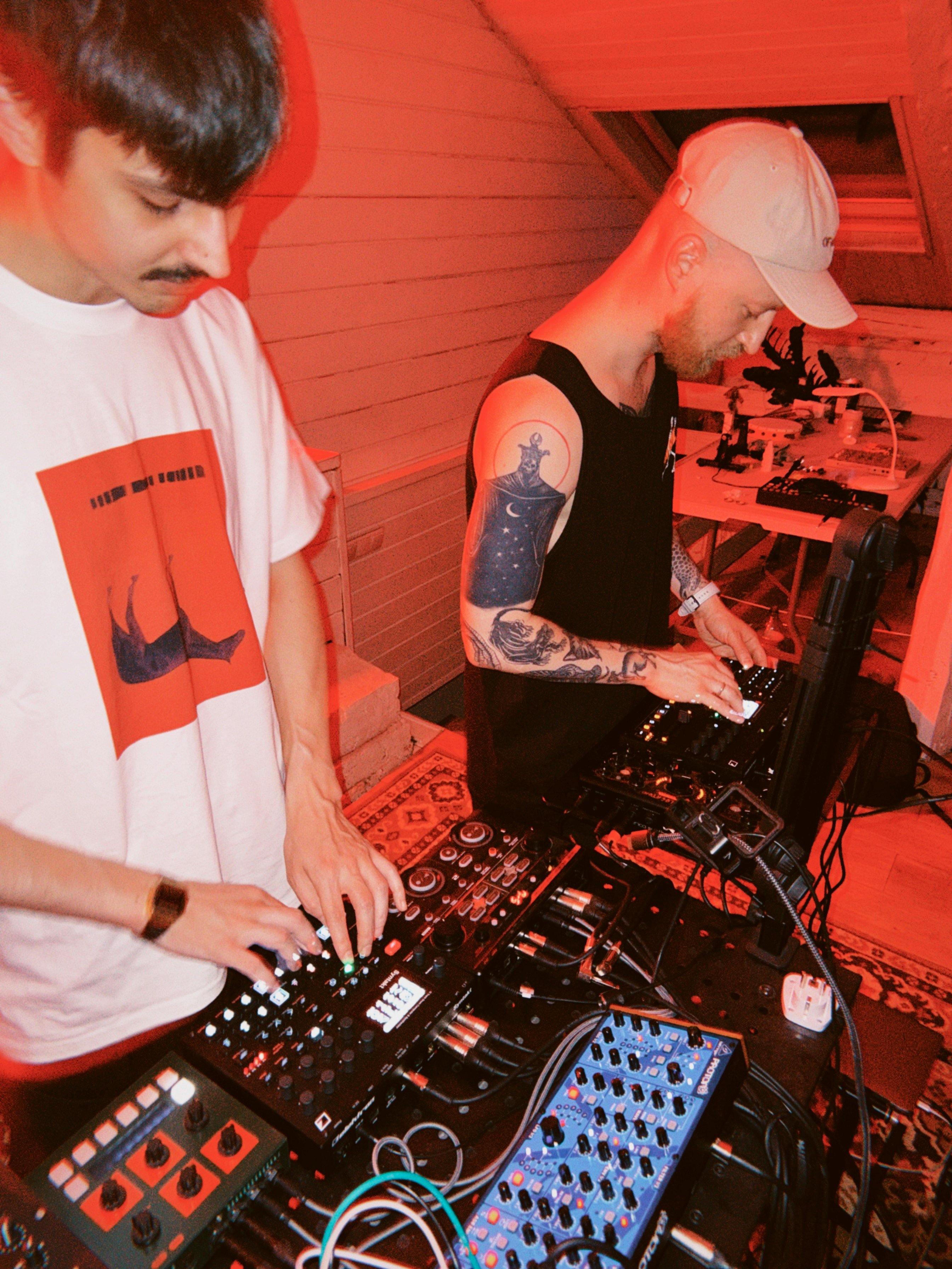 Two Men Operating Electronic Music Equipment Under Red Light. HD mobile wallpaper