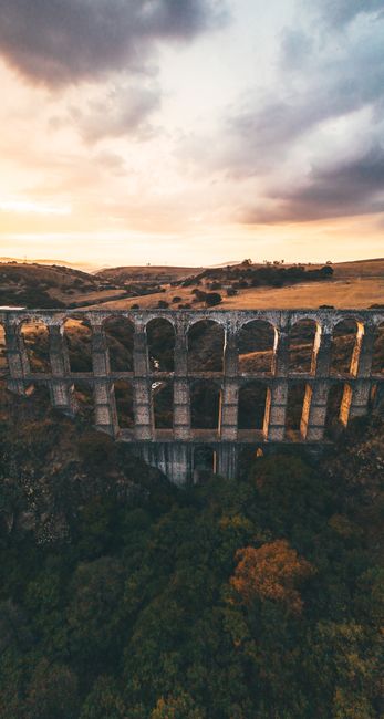 Stunning Aerial Shot Of A Historic Stone Aqueduct Set Against A Dramatic Sunset Sky. wallpaper preview
