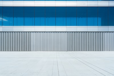 Modern Building Facade With Blue Windows And Grey Textured Wall. wallpaper preview