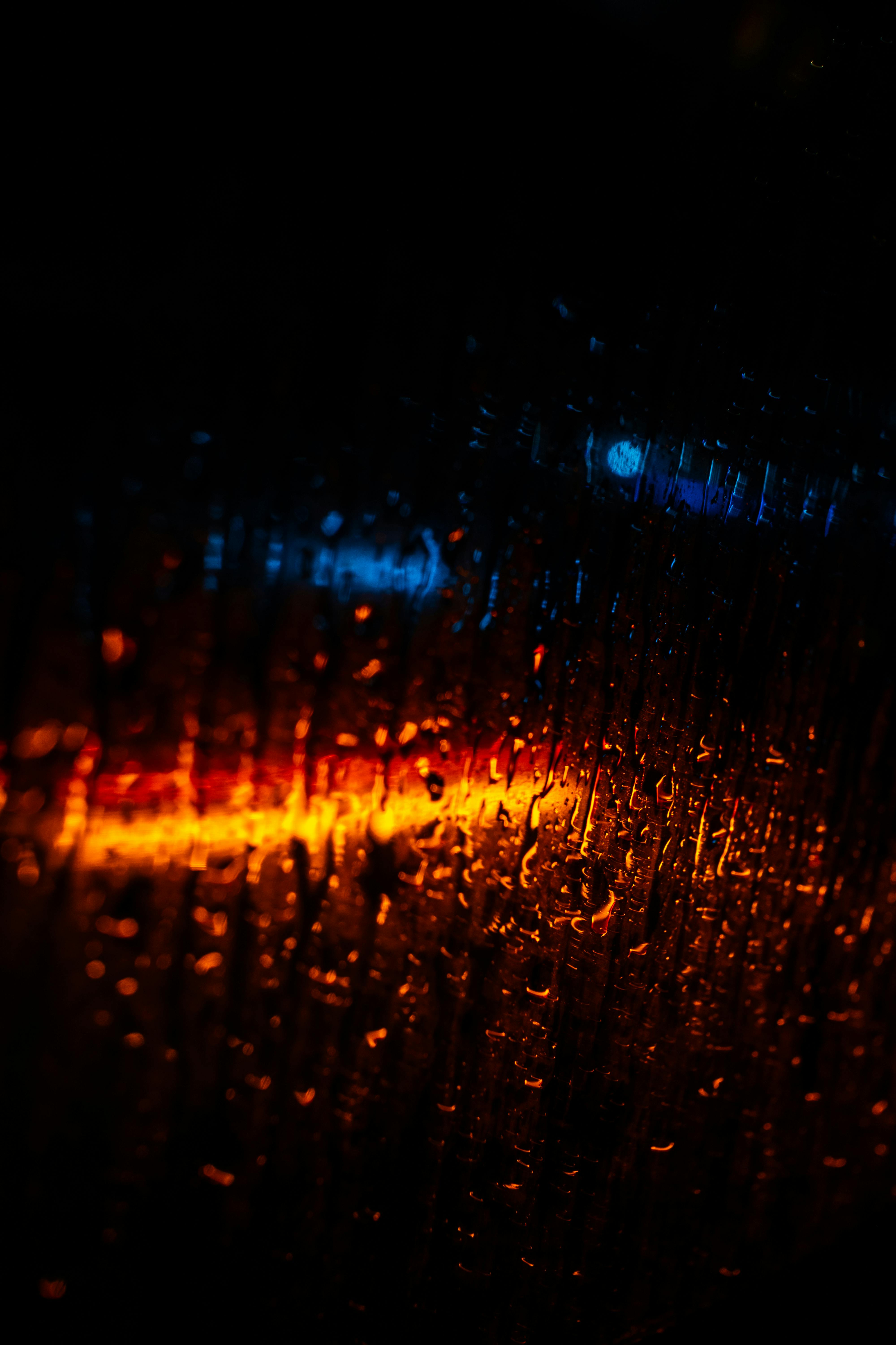 雨点滴在玻璃上绽放的蓝橙色光芒手机壁纸高清图片