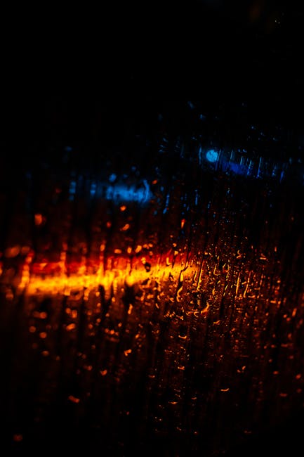 Vibrant Abstract Of Raindrops On Glass With Blue And Orange Lights.