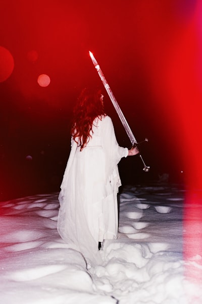 白衣女神持燃烧剑于绯红雪野壁纸预览