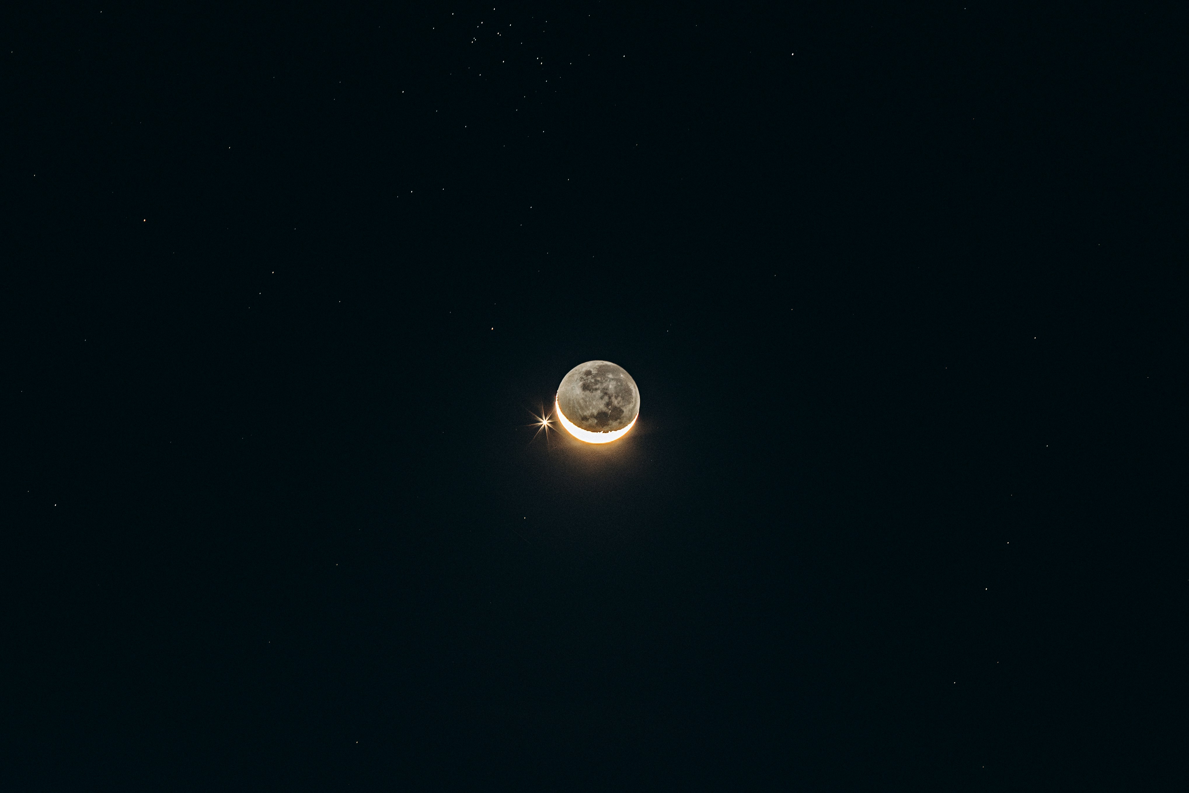 半圓月亮與光芒萬丈的星星在漆黑的星空中對峙手機桌布高清圖片