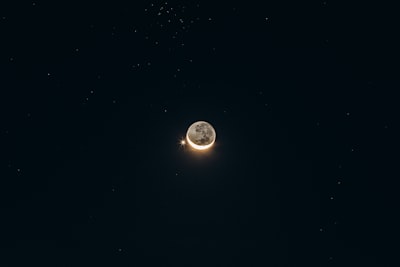 半圓月亮與光芒萬丈的星星在漆黑的星空中對峙桌布預覽