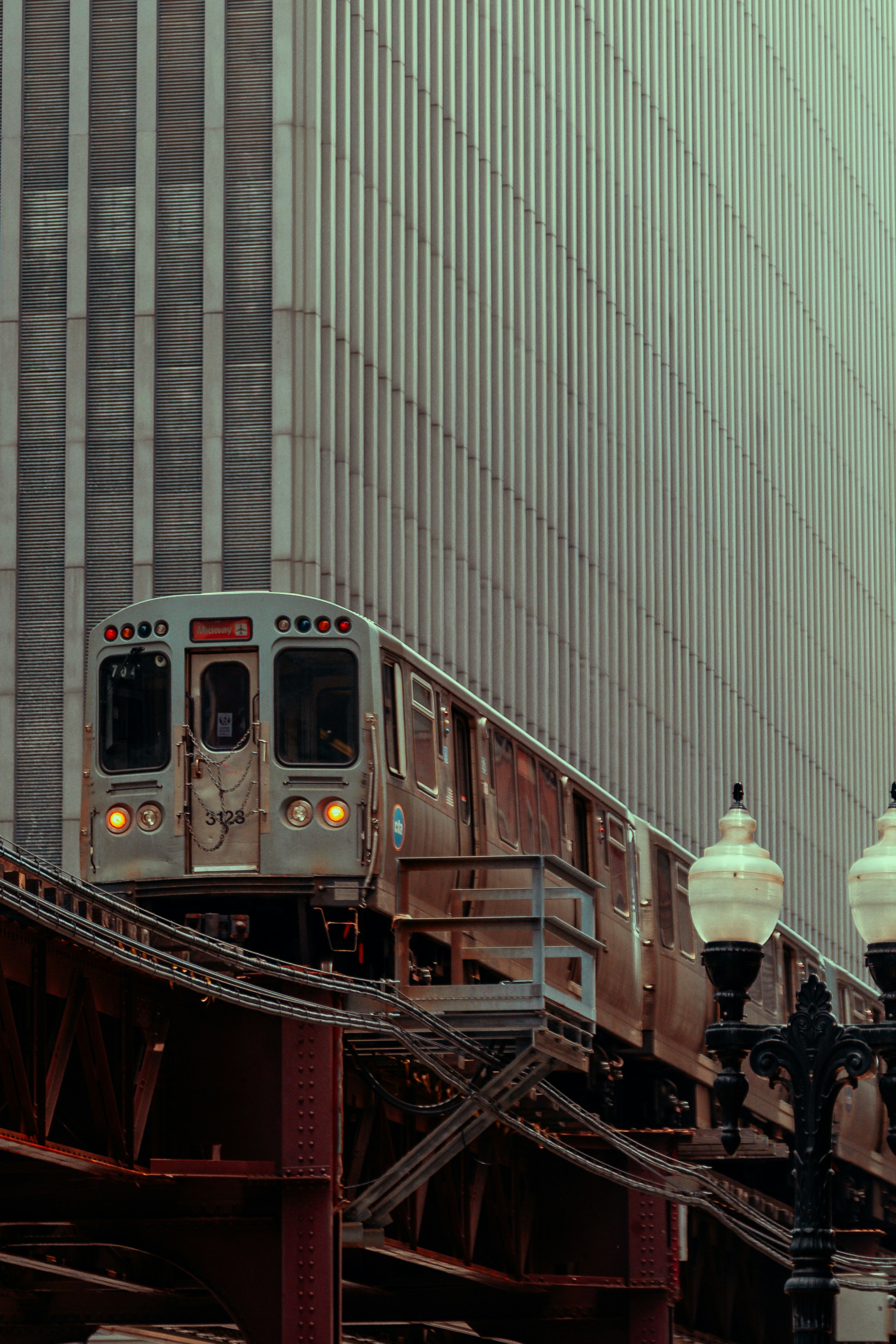A Train On Elevated Tracks Passes A Modern Building. HD mobile wallpaper