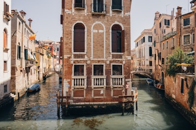 A Narrow Canal In Venice With Old Brick Buildings. wallpaper preview