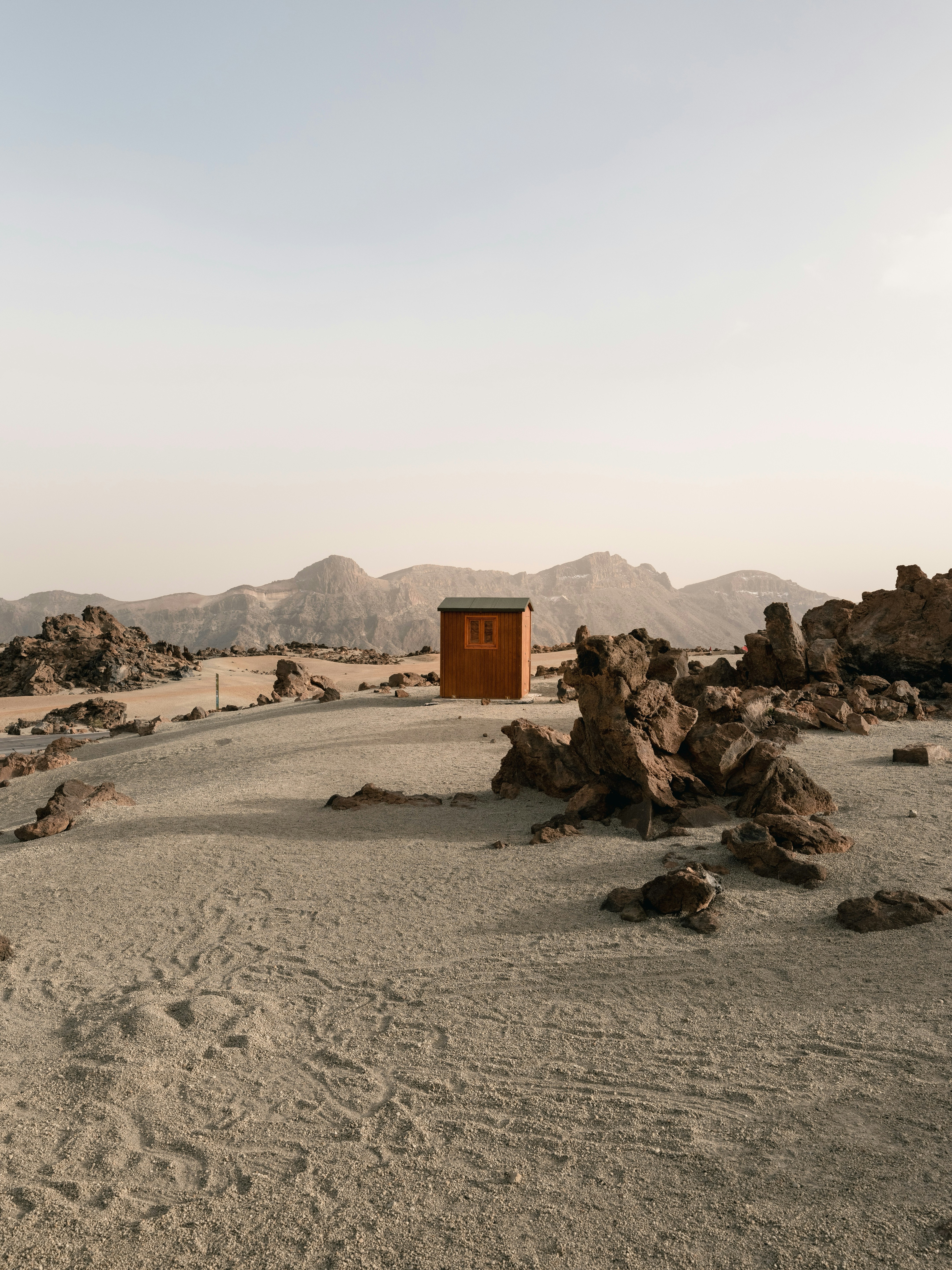A Small Wooden Cabin In A Vast, Rocky Desert Landscape. HD mobile wallpaper