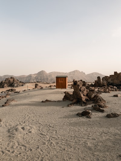 A Small Wooden Cabin In A Vast, Rocky Desert Landscape. wallpaper preview