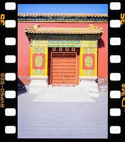 Vibrant Red Traditional Chinese Door With Ornate Yellow Roof. wallpaper preview
