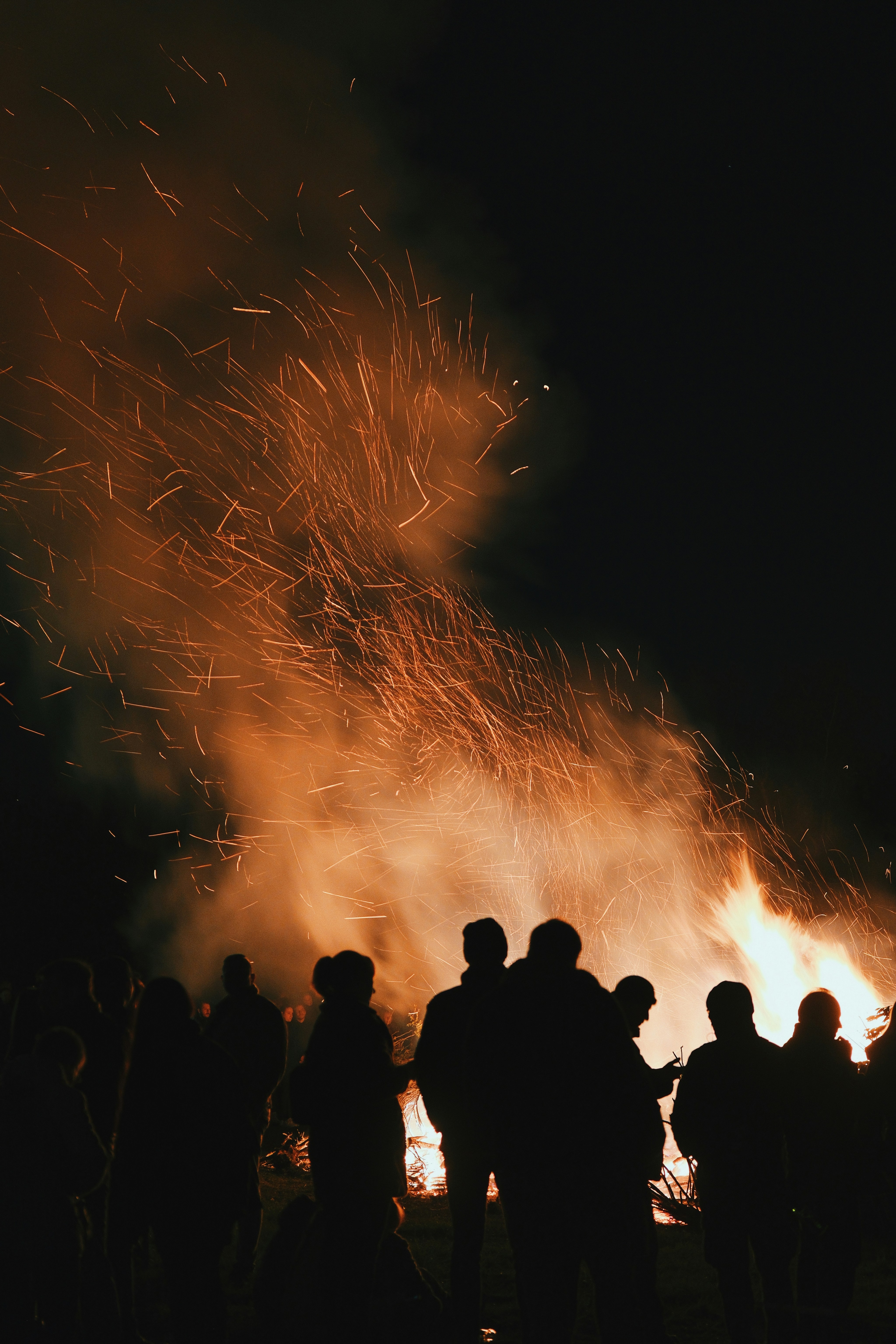Silhouettes Of People Gathered Around A Large Bonfire At Night. HD mobile wallpaper