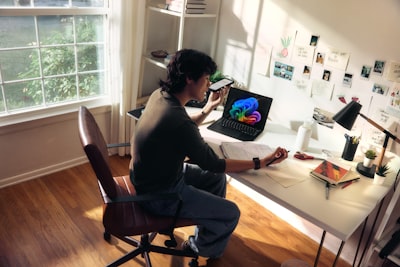 Person Working At A Desk With A Laptop And Books. wallpaper preview
