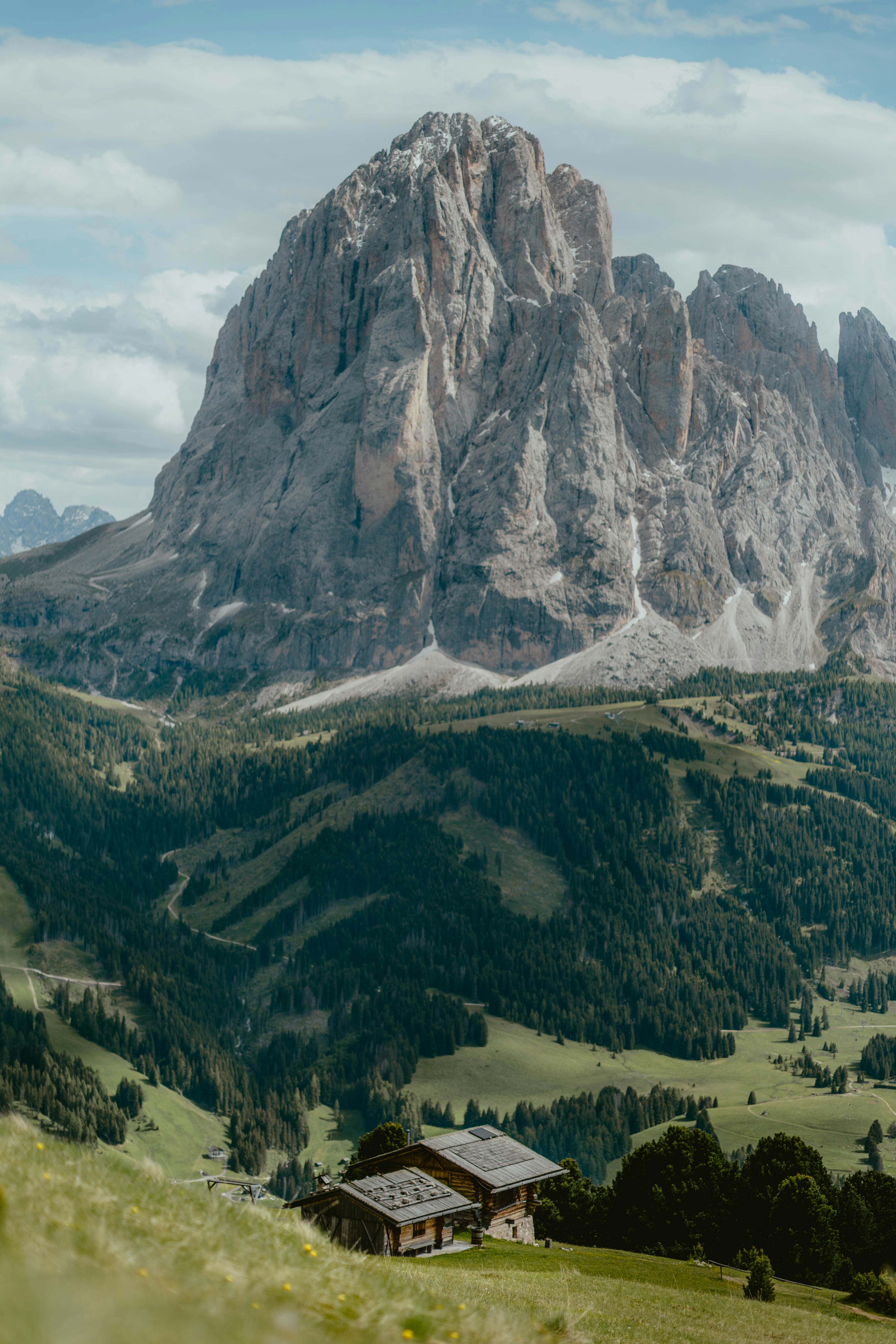 Alpine House Nestled In A Valley Beneath A Towering Mountain. HD mobile wallpaper