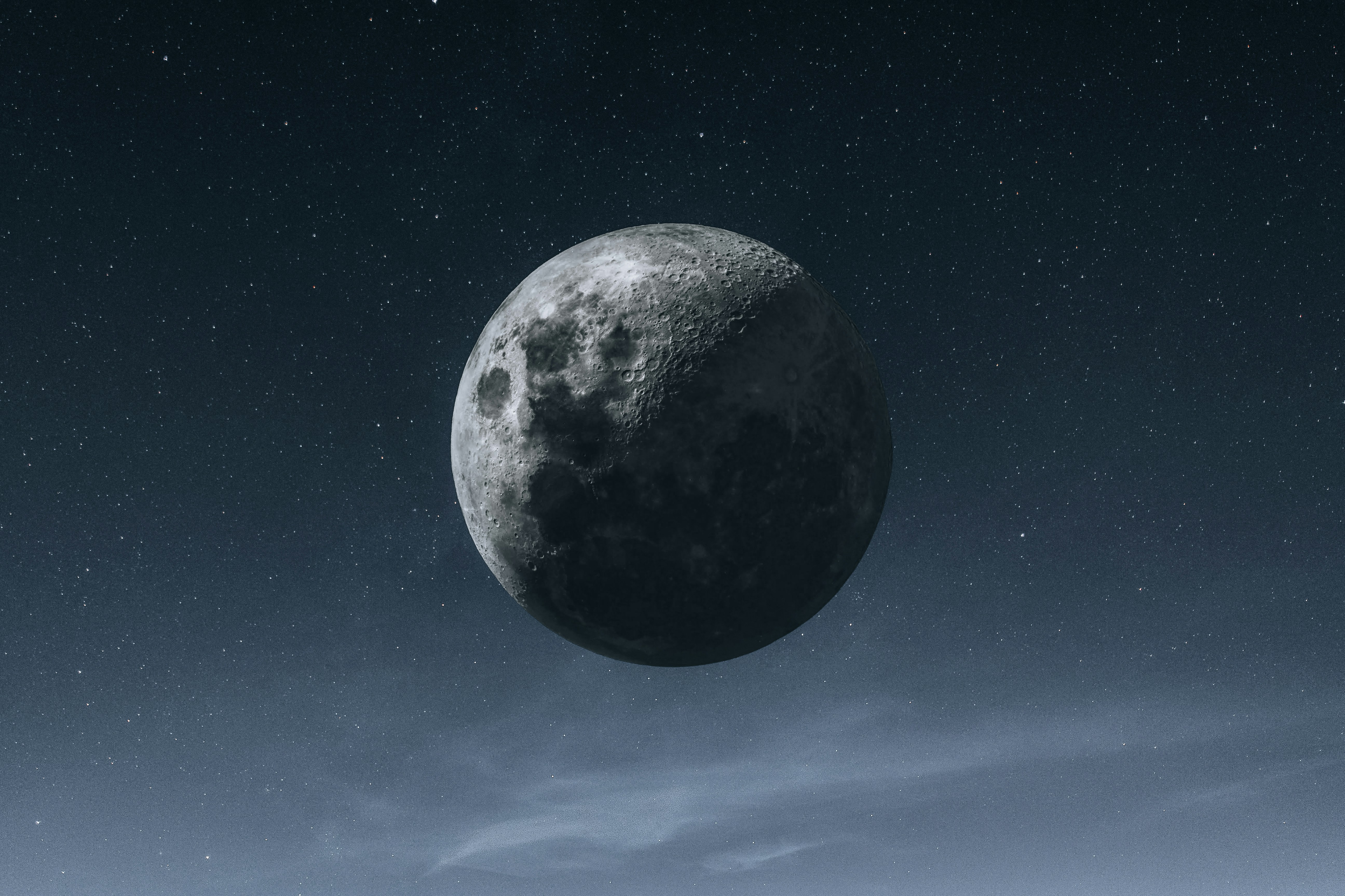 A Striking Close-up Of The Moon Dominates The Night Sky, Revealing Intricate Craters, Rugged Terrain, And Contrasting Light And Shadow Across Its Surface. Countless Stars Sparkle In The Dark Blue Sky, While A Thin Layer Of Soft Clouds Drifts Along The Lower Edge Of The Frame, Adding Depth And Atmosphere. The Composition Creates A Peaceful Yet Dramatic View Of The Moon Suspended Above The Earth. HD mobile wallpaper