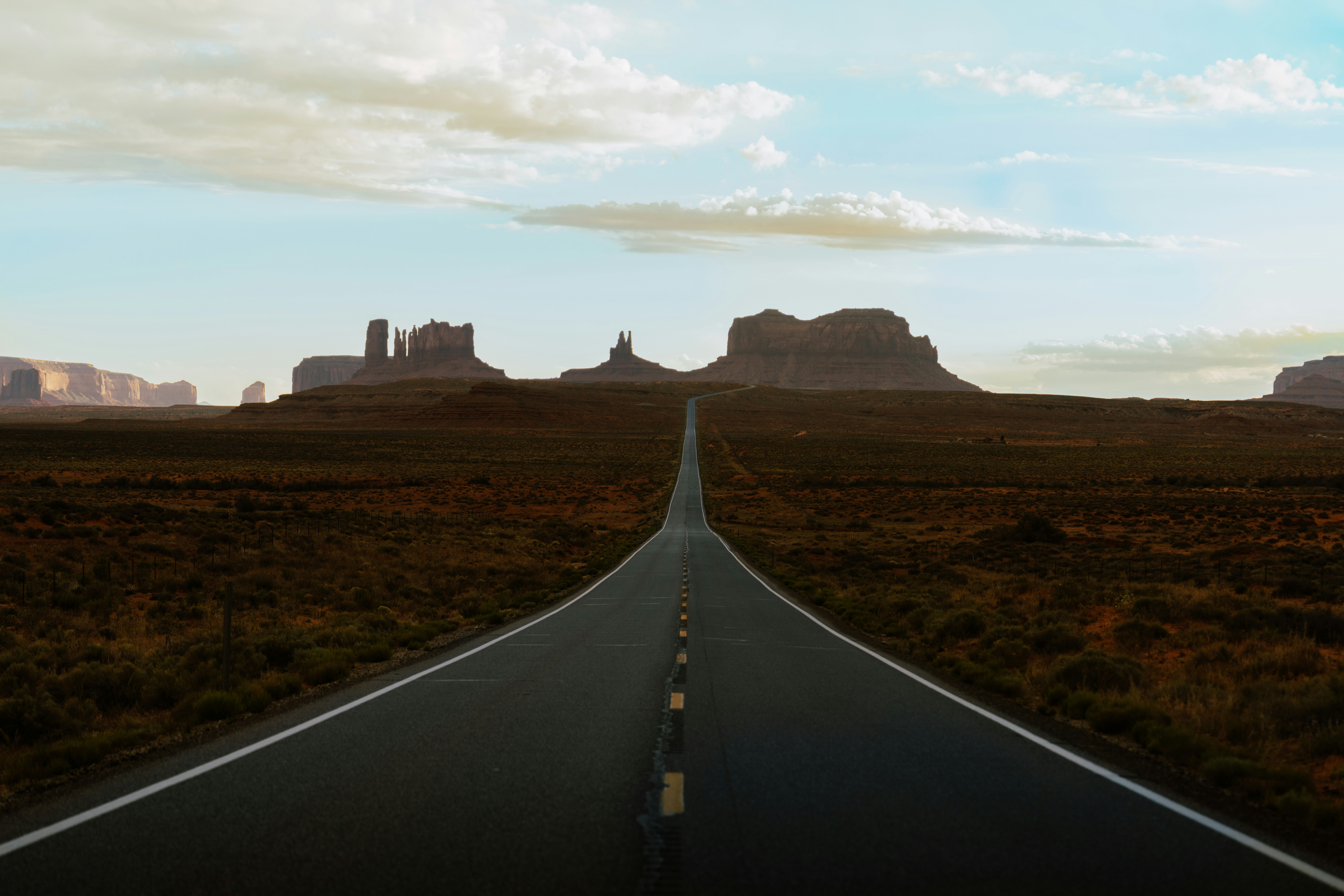 Long Straight Road Leading To Distant Desert Mesas HD mobile wallpaper