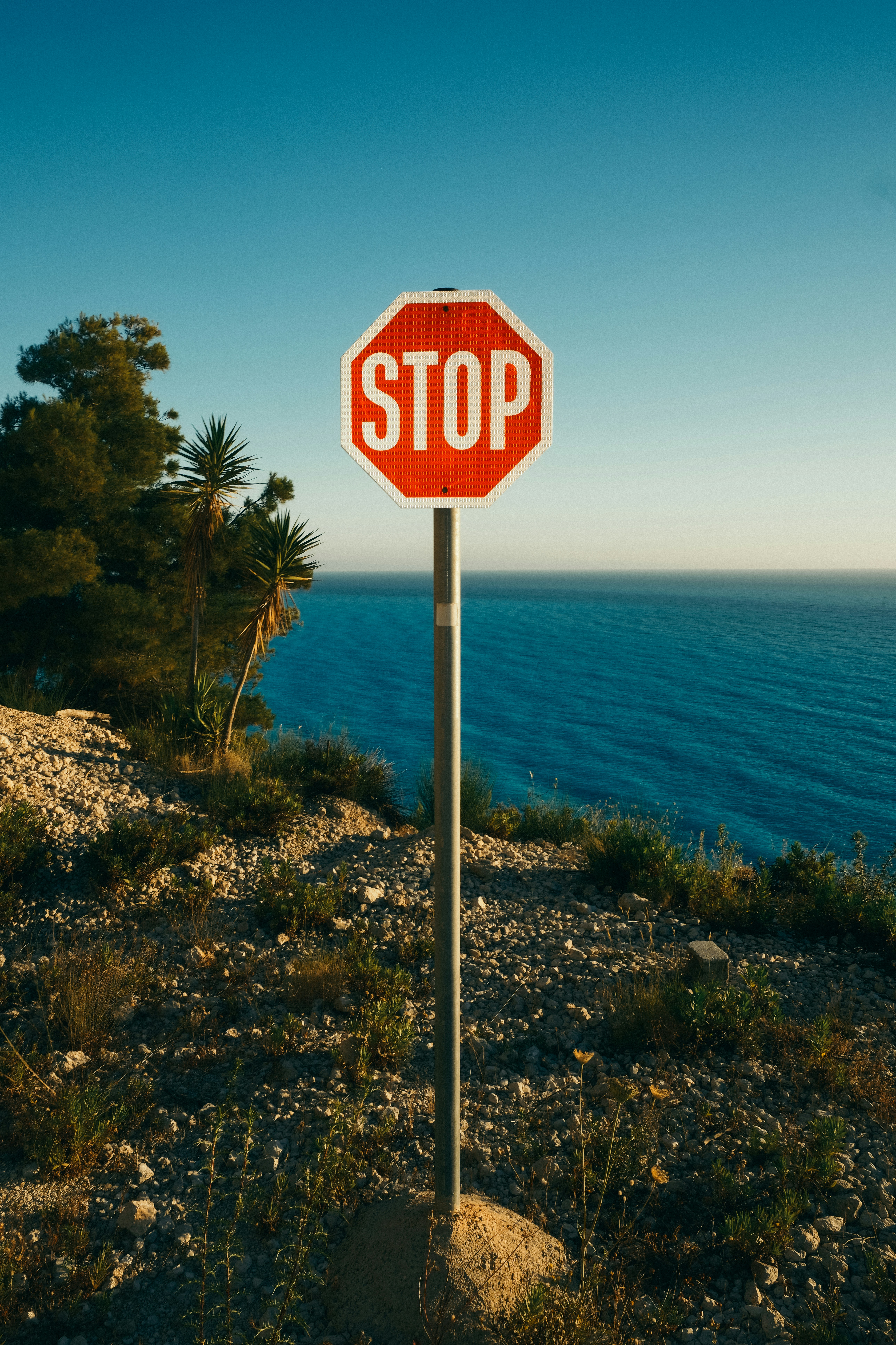 A Stop Sign Overlooking A Vast Blue Ocean. HD mobile wallpaper