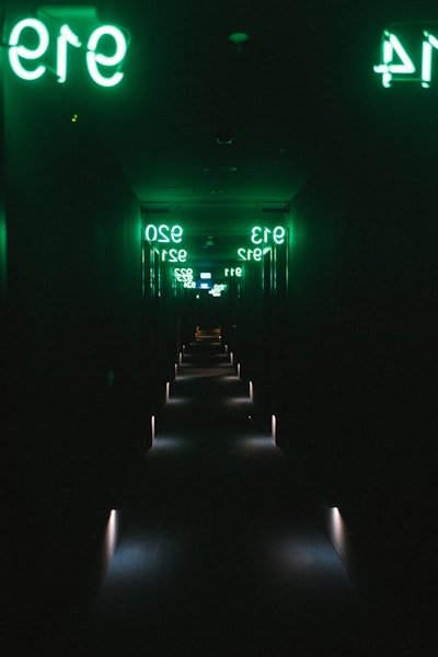 A Dark Hallway With Green Neon Signs And Illuminated Floor. wallpaper preview