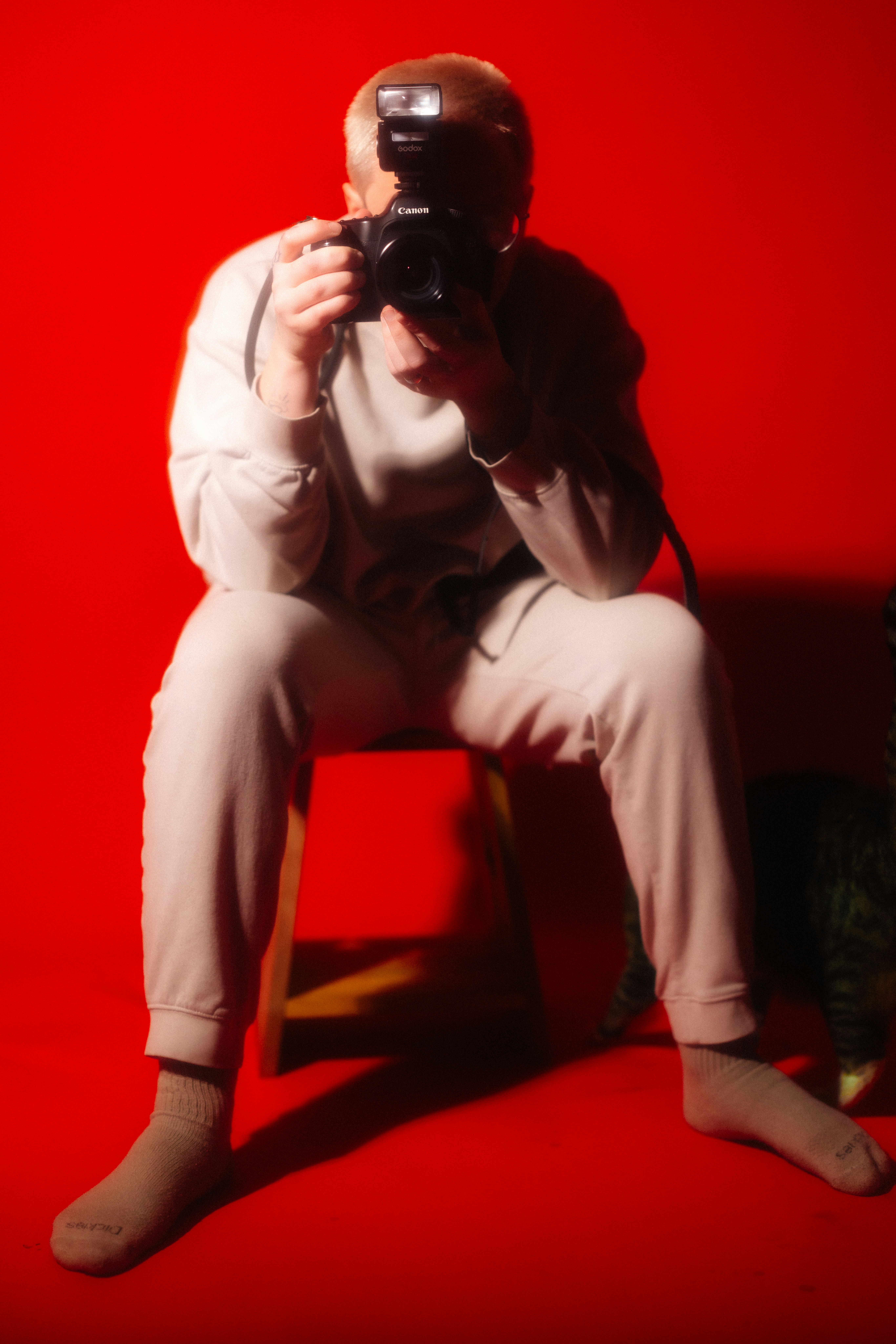 Person With Camera Takes A Photo Against Red Background. HD mobile wallpaper