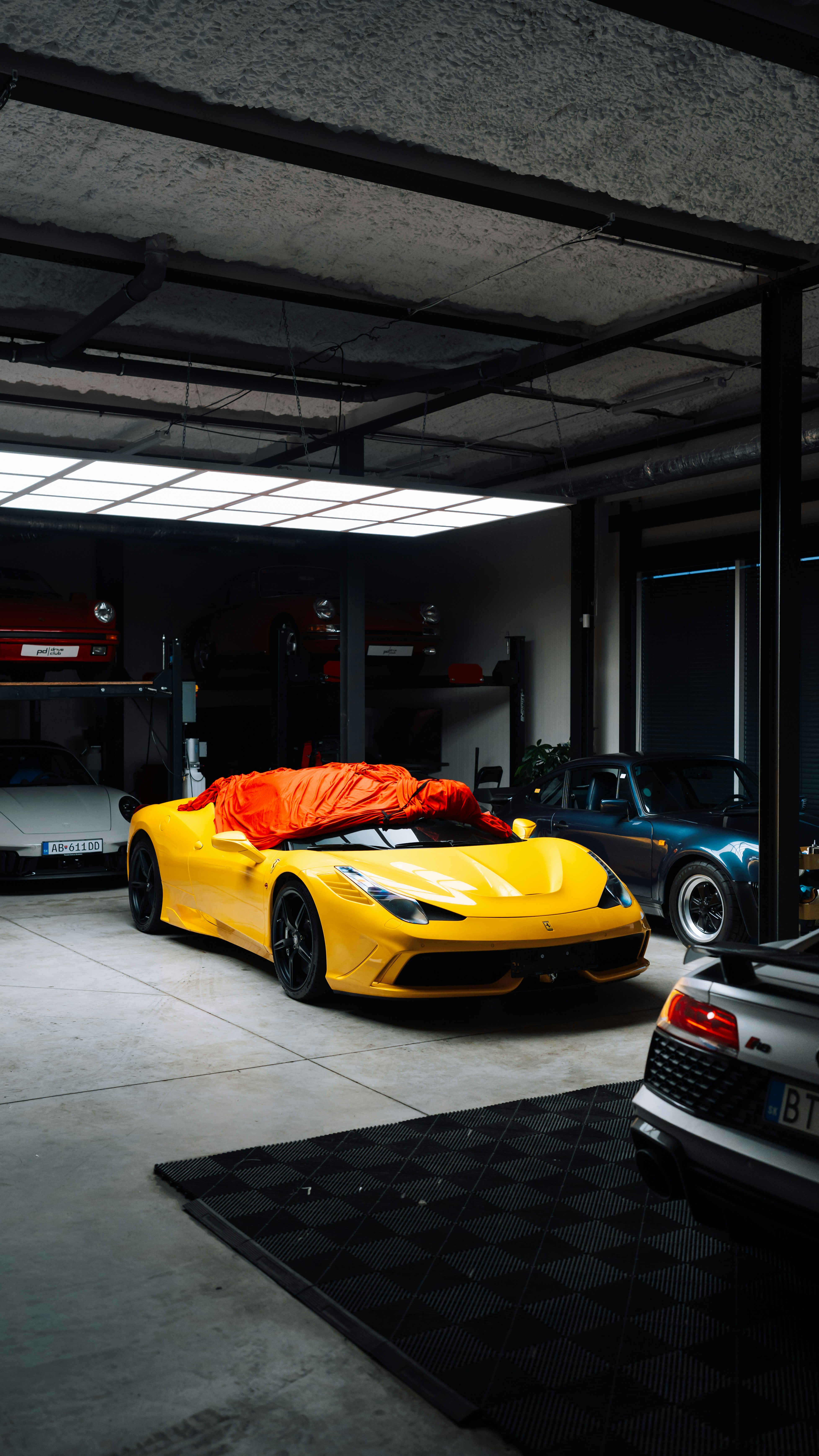 Yellow Sports Car Covered With Orange Tarp In Garage. HD mobile wallpaper