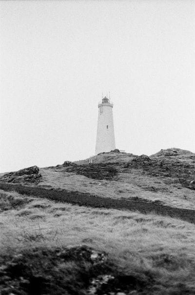 A Lighthouse Stands On A Grassy Hill. wallpaper preview