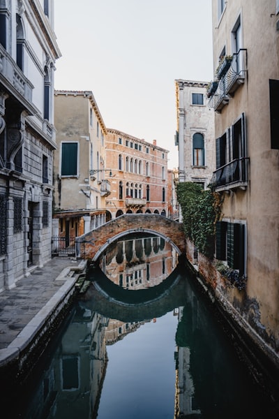 Historic Venetian Canal With Arched Bridge And Building Reflections. wallpaper preview