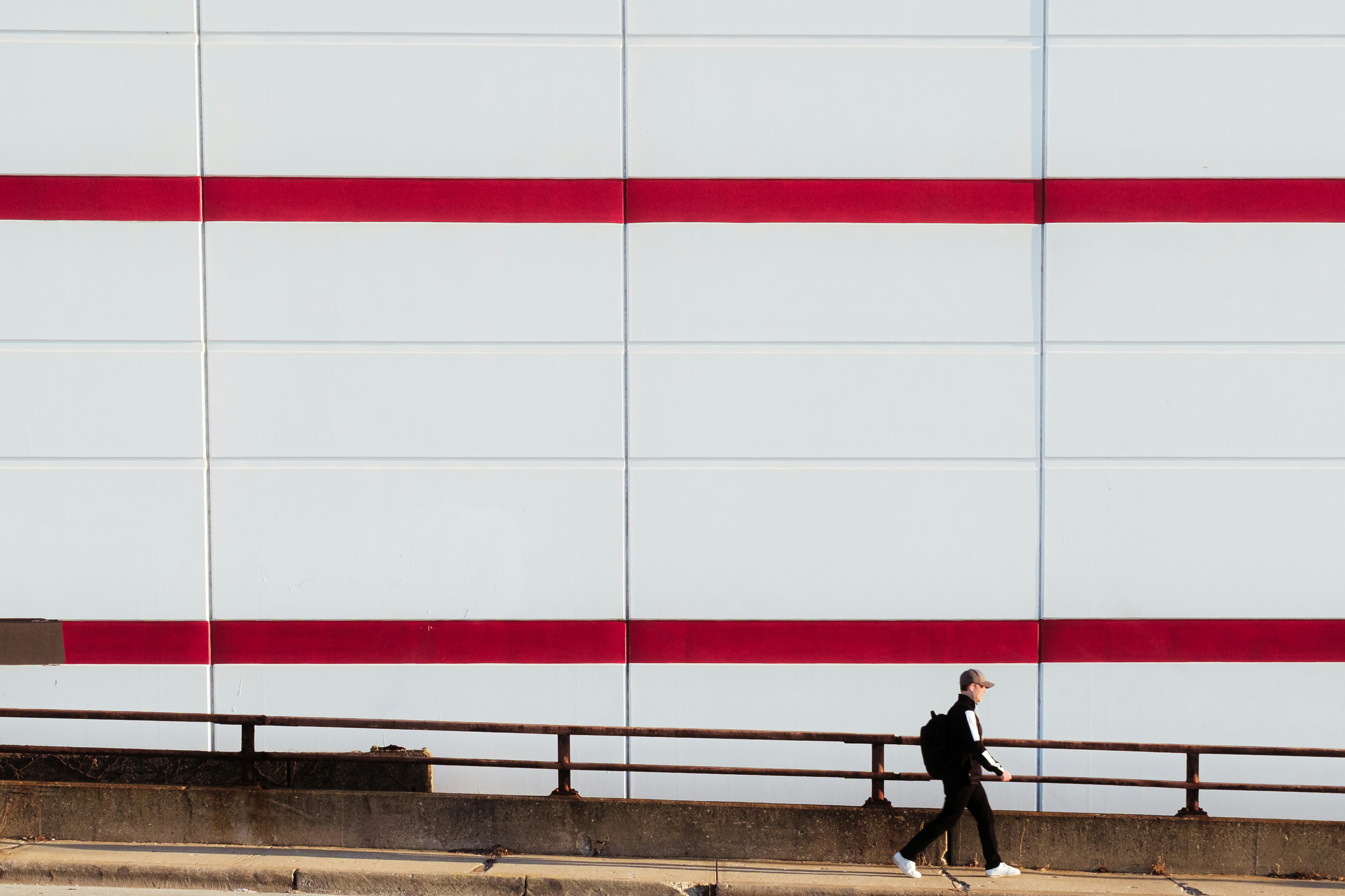 Man Walks Past A Building With Red Stripes. HD mobile wallpaper