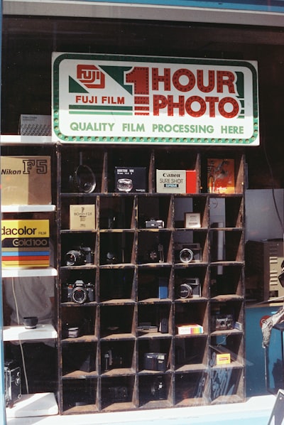 Fuji Film 1 Hour Photo Sign Above Cameras In Window. wallpaper preview
