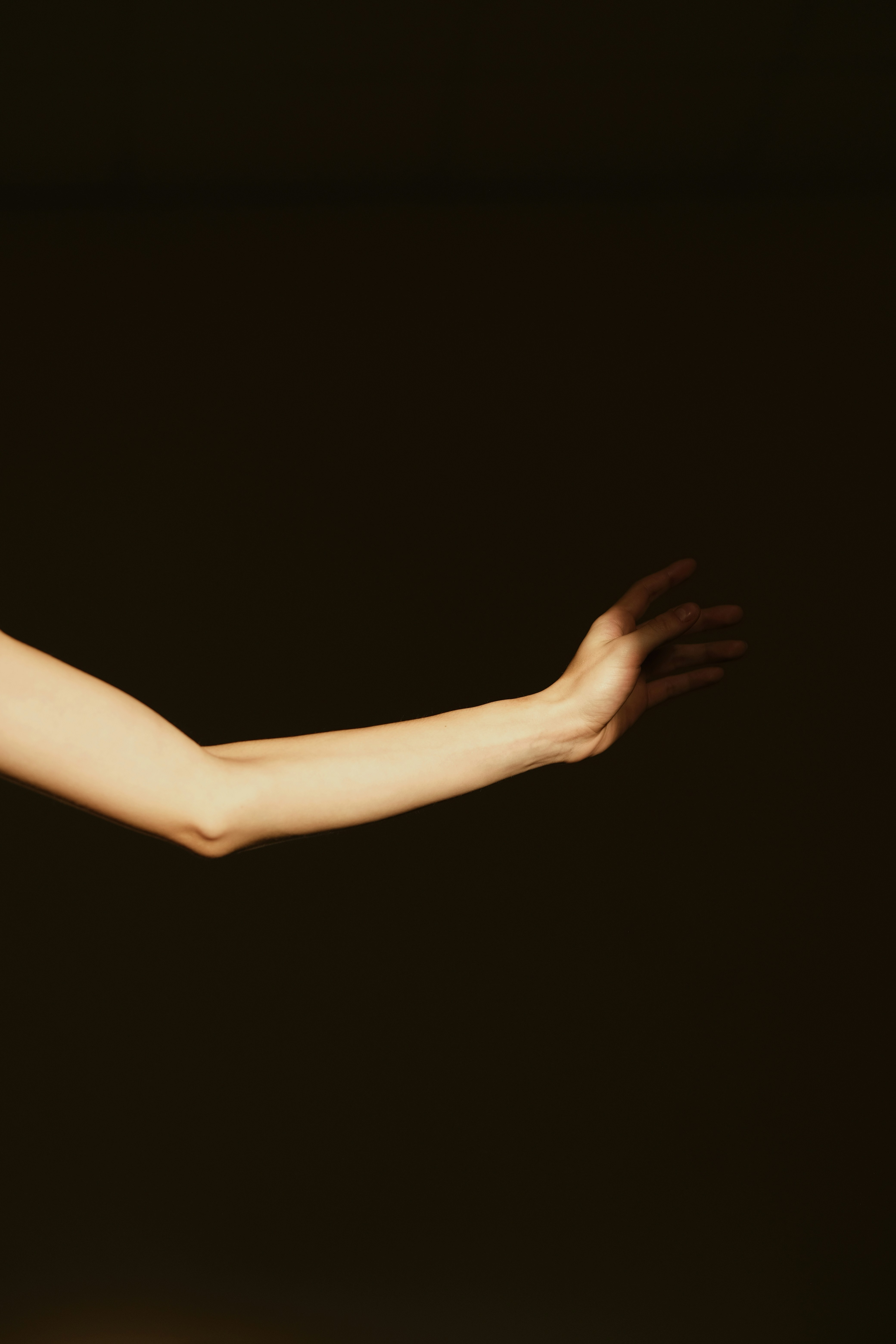 A Person's Arm And Hand Extended In A Dark Setting. HD mobile wallpaper