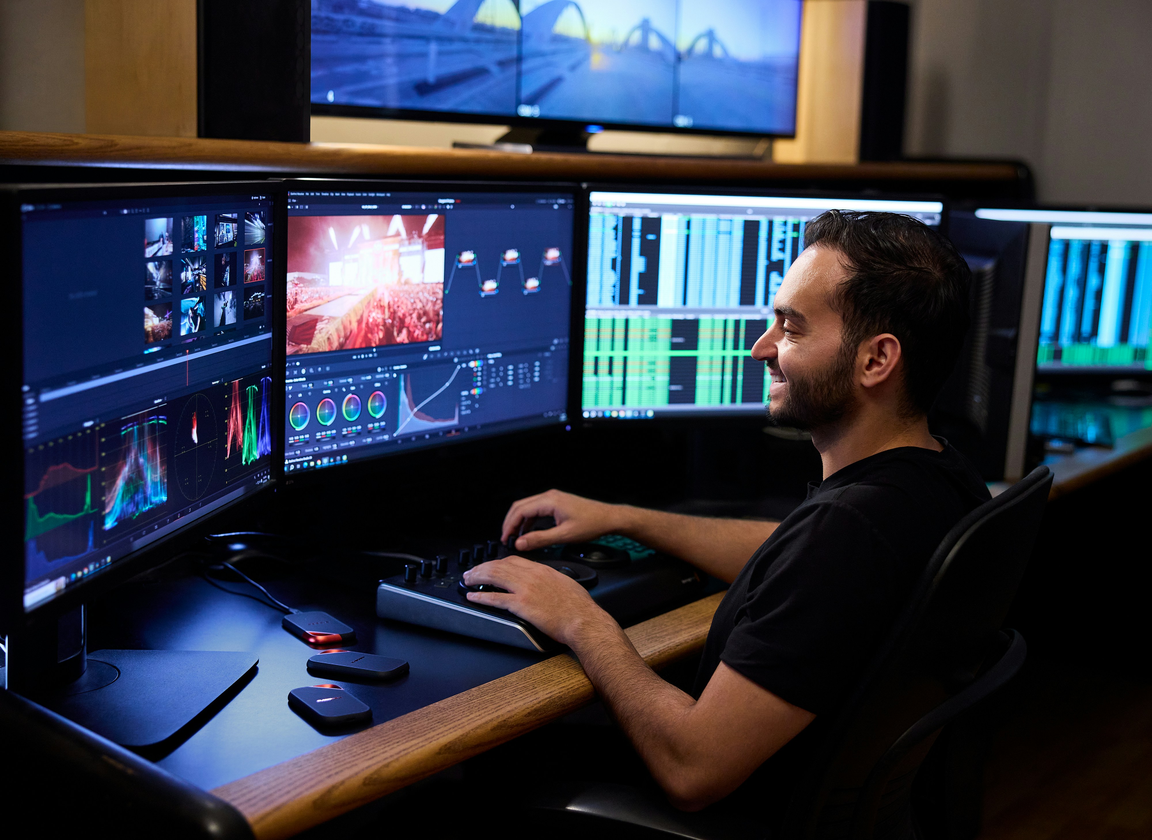 Smiling Man Editing Video On Multiple Computer Monitors. HD mobile wallpaper