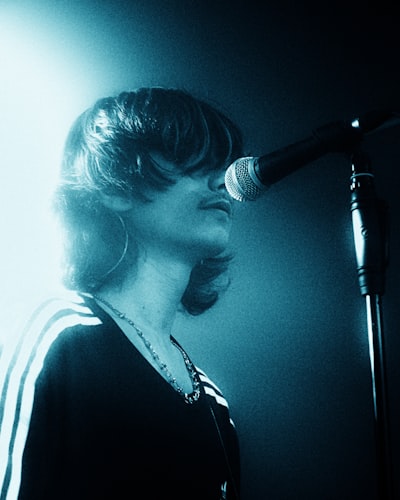 Performer With Long Hair And Mustache Sings Into A Microphone. wallpaper preview