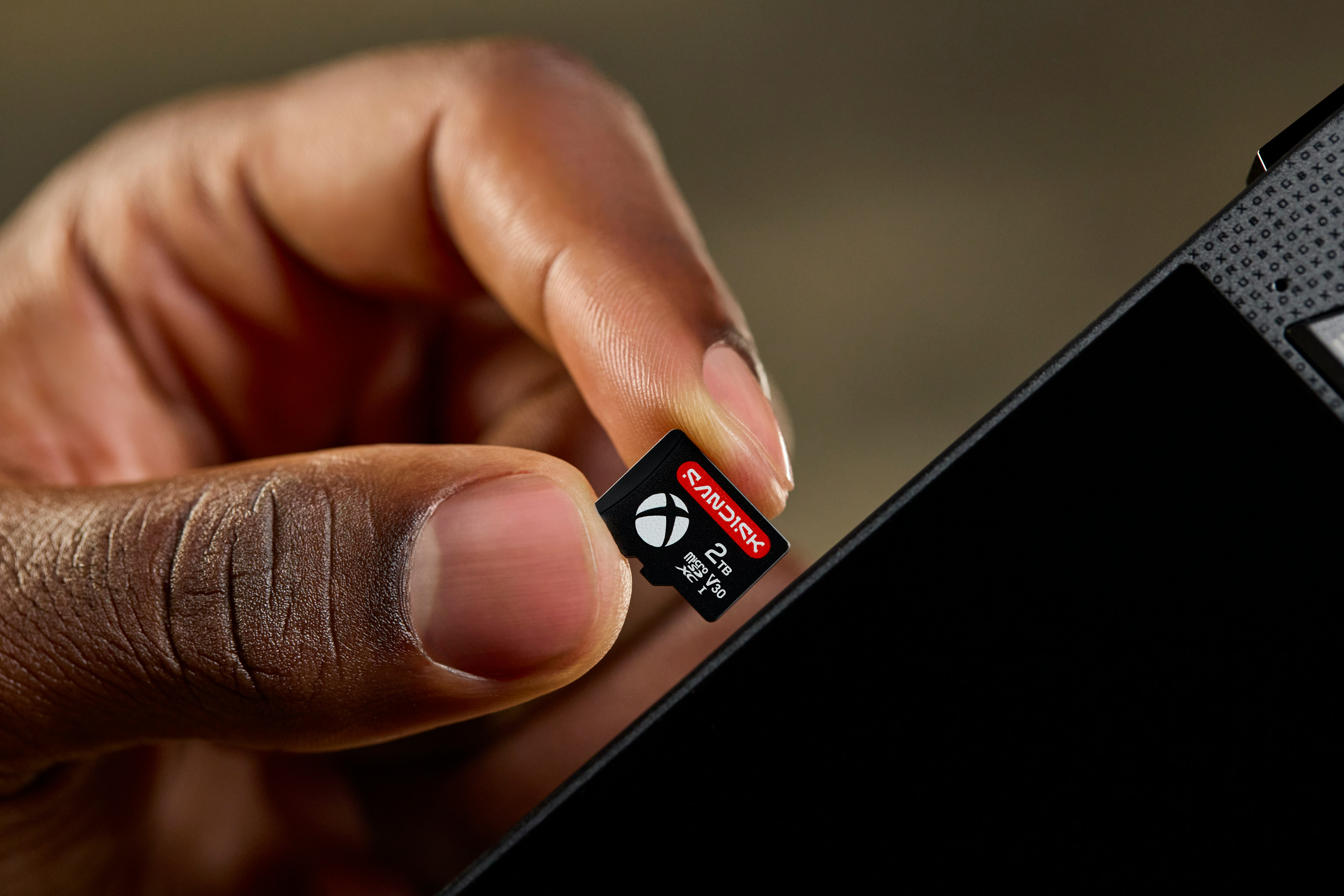Hand Inserting An Xbox Microsd Card Into A Device. HD mobile wallpaper