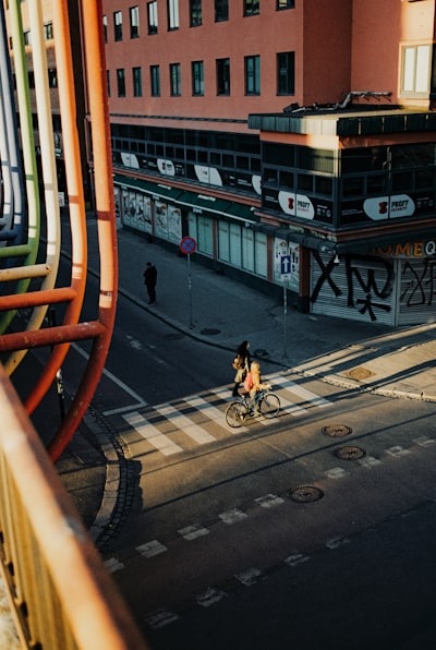 Urban Street Scene With Cyclist, Buildings, And Colorful Bridge. wallpaper preview