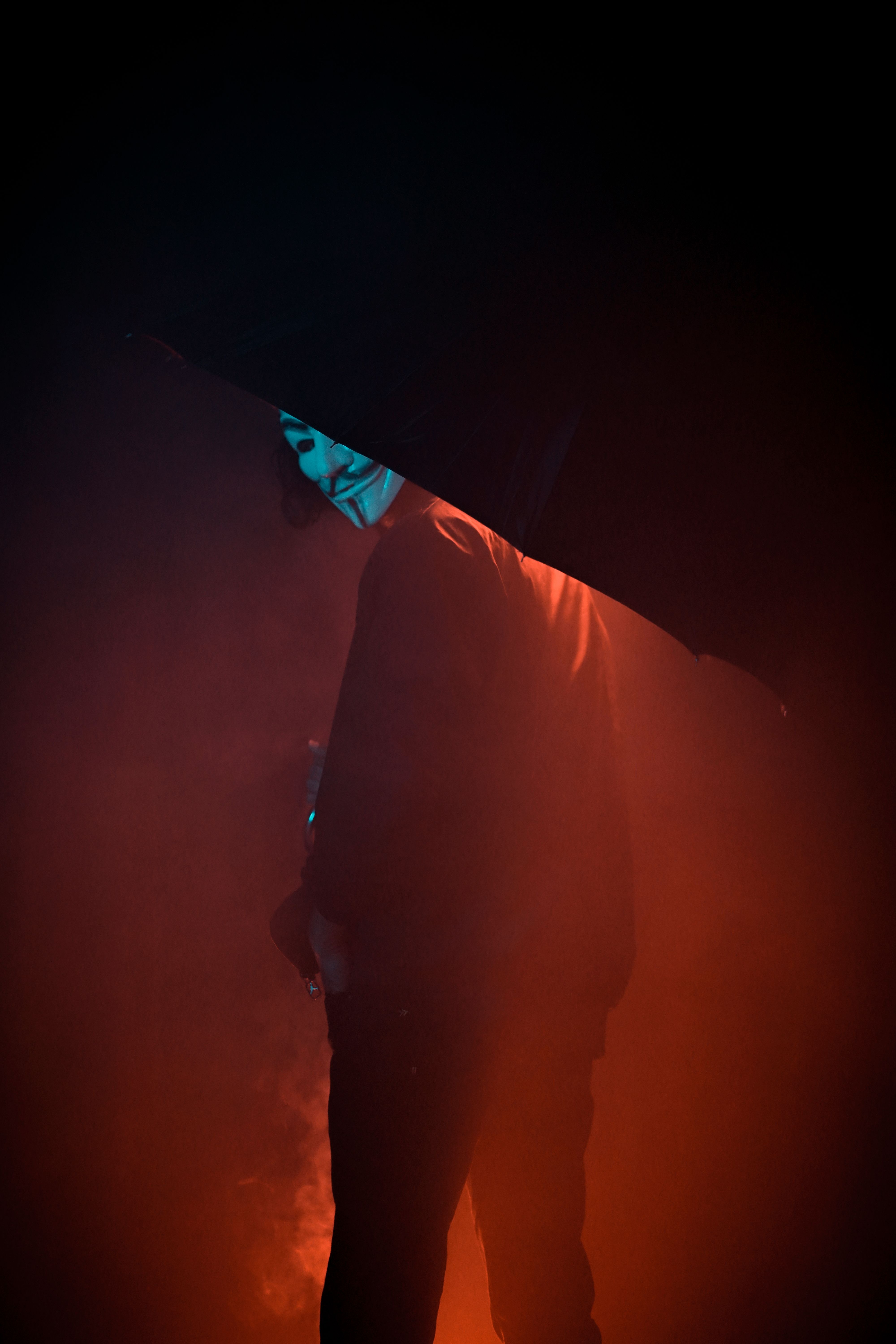 A Person In A Dark Setting With Intense Red Light, Wearing A Mask. HD mobile wallpaper