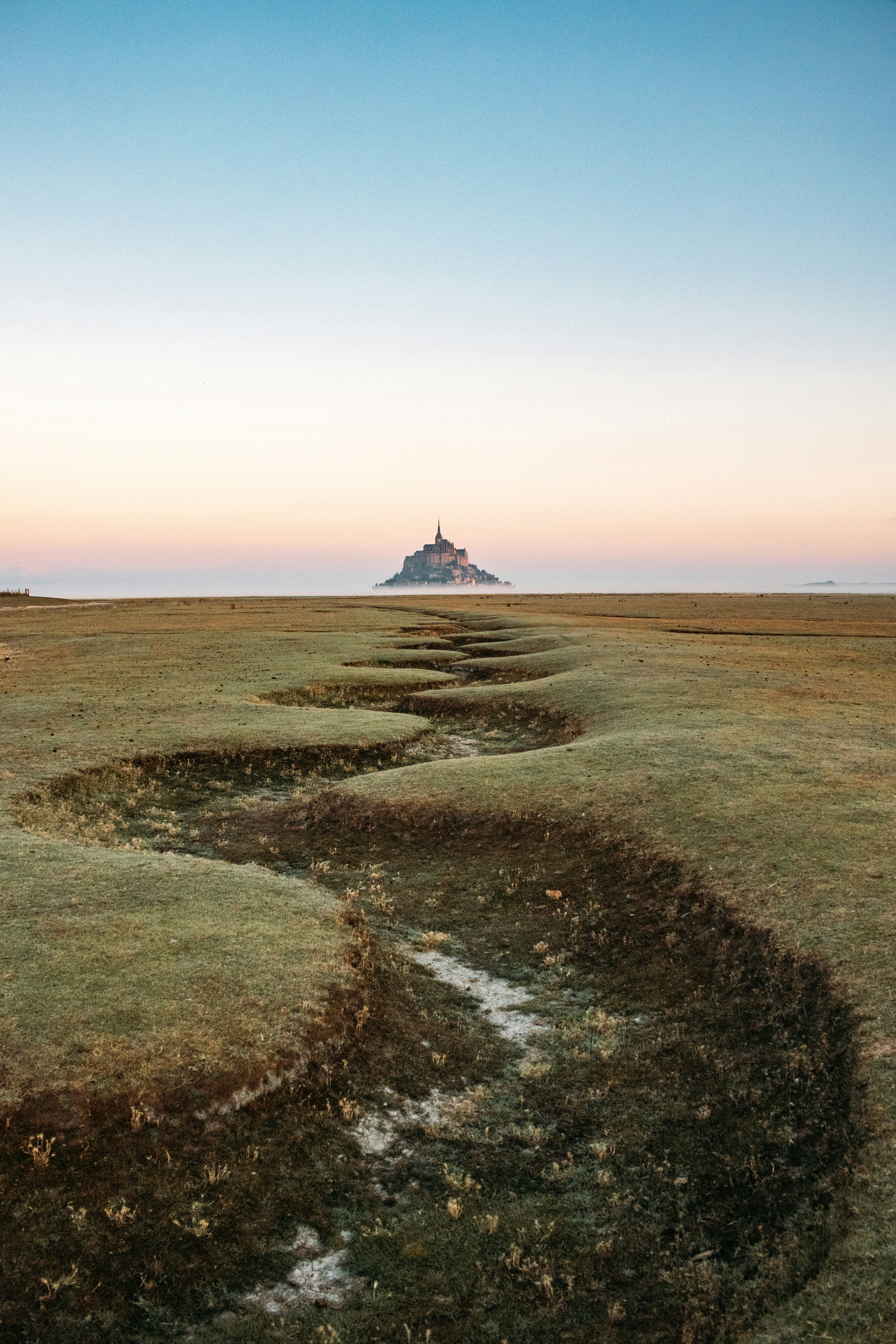 Mont Saint-michel Across A Winding Grassy Plain At Dawn. HD mobile wallpaper
