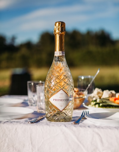 A Bottle Of Prosecco On A White Table Outdoors. wallpaper preview