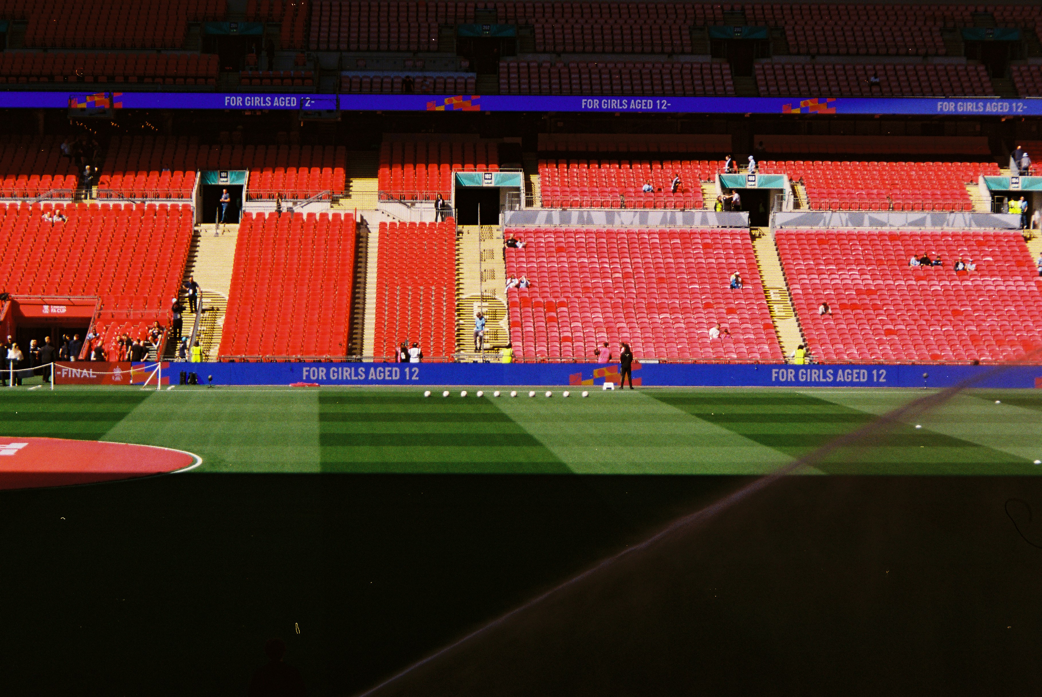 Empty Red Stadium Seats With A Green Sports Field. HD mobile wallpaper