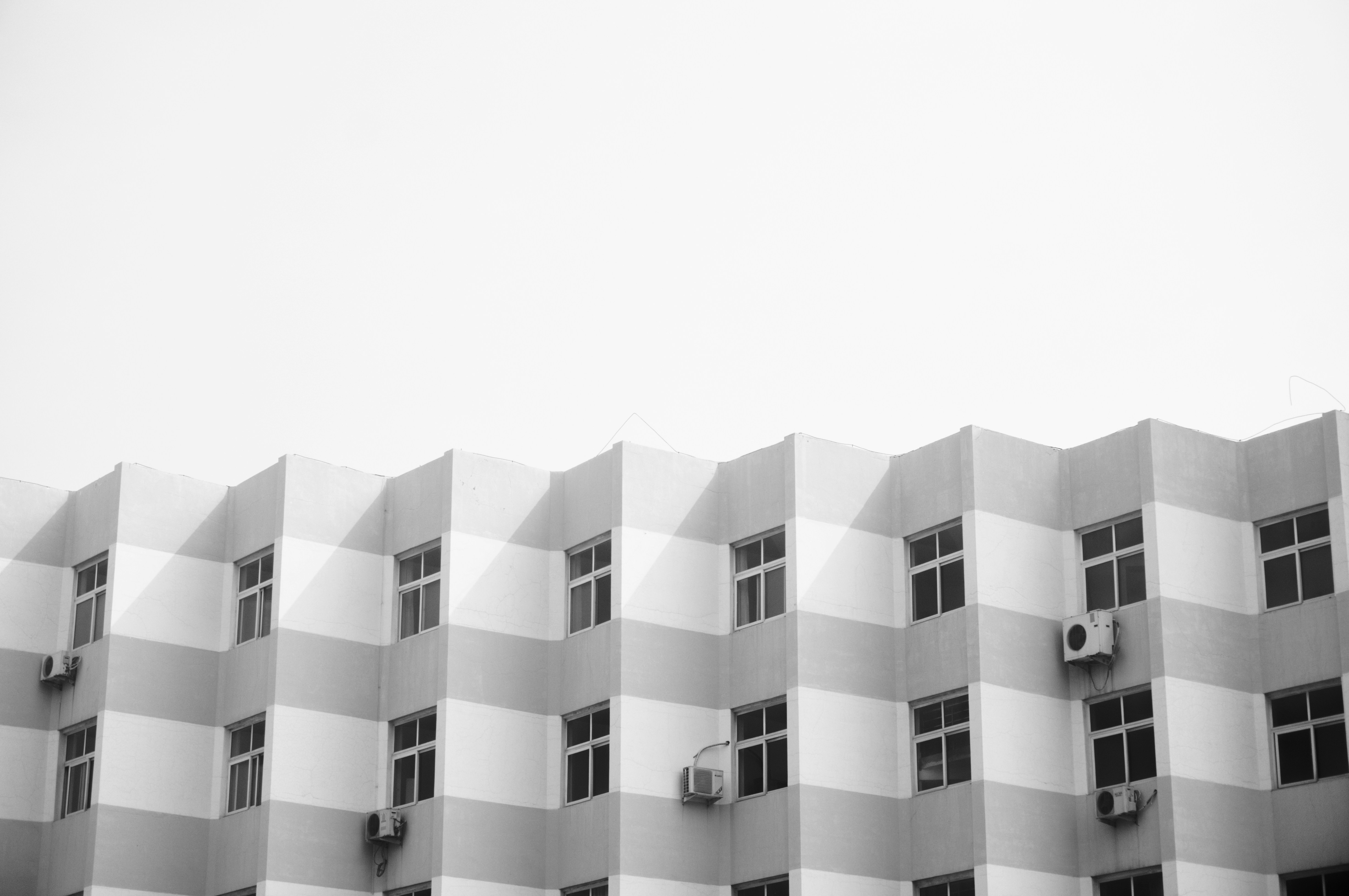 Monochromatic Building With A Zigzag Checkerboard Pattern And Windows. HD mobile wallpaper