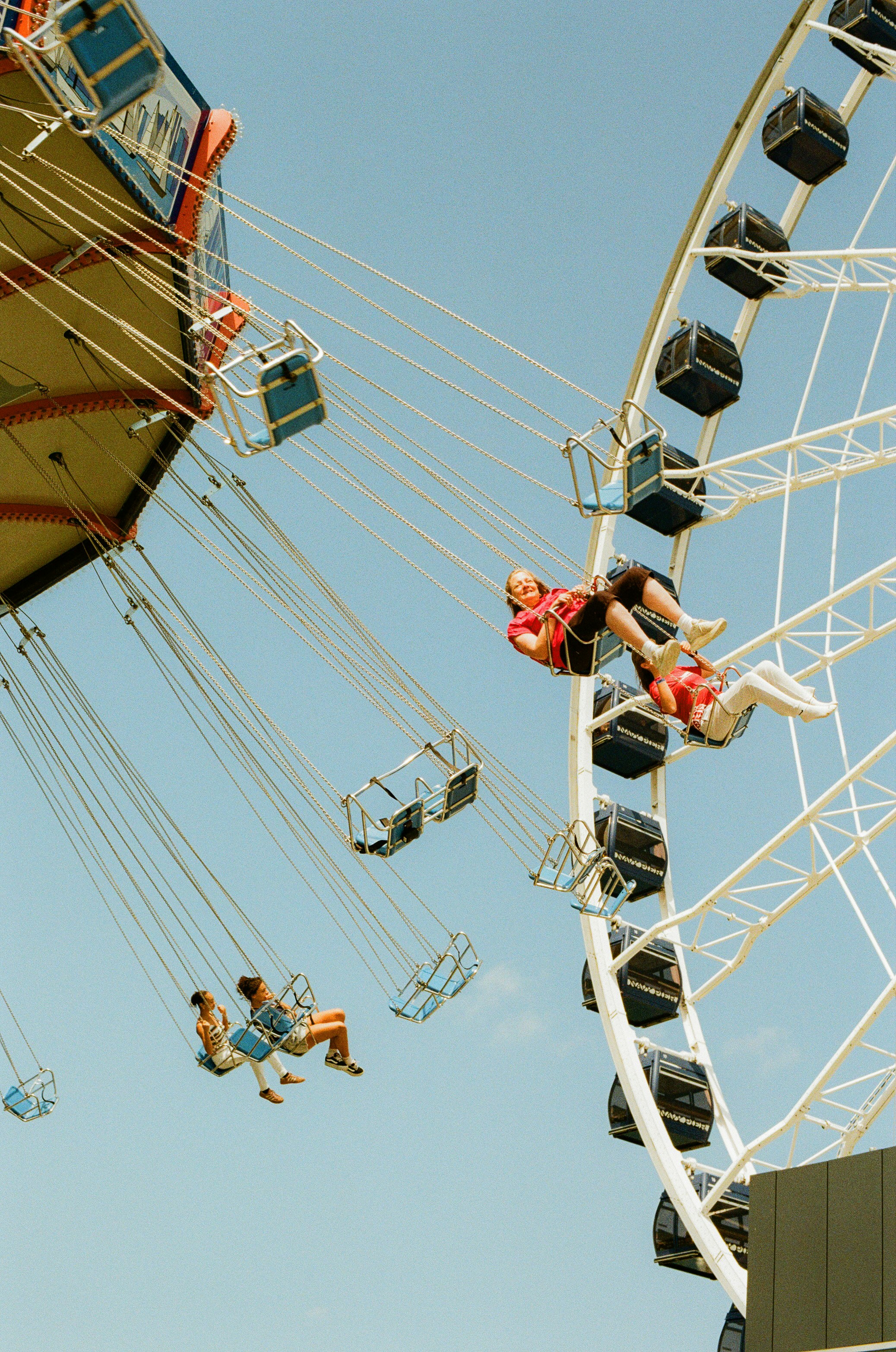 A Nostalgic Summer Scene At Navy Pier In Chicago, With Swing Chairs Flying Through The Blue Sky Beside The Ferris Wheel. Captured On Film With A Warm, Timeless Amusement Park Feeling. HD mobile wallpaper