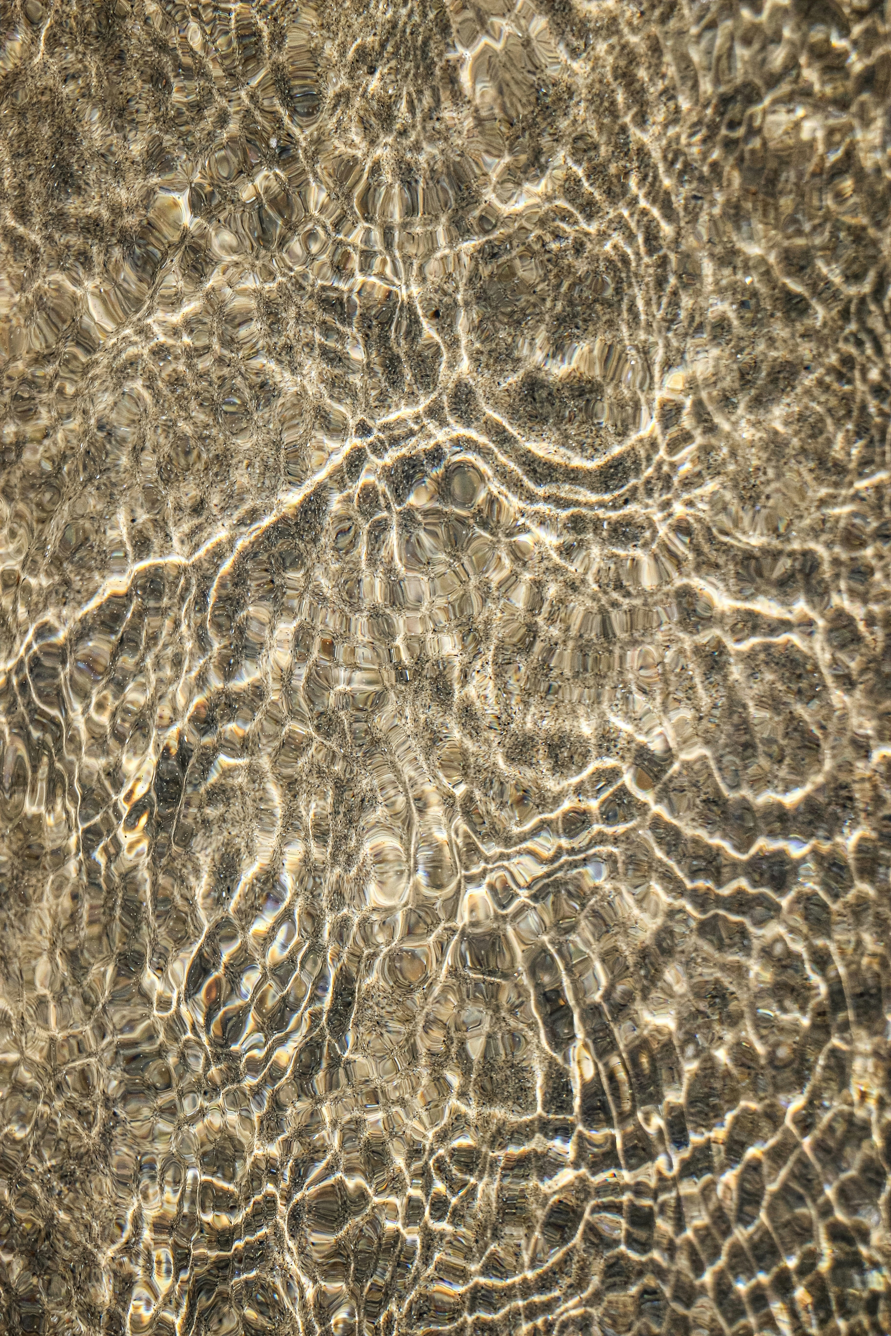 Rippling Water Creating Light Patterns On A Sandy Surface. HD mobile wallpaper