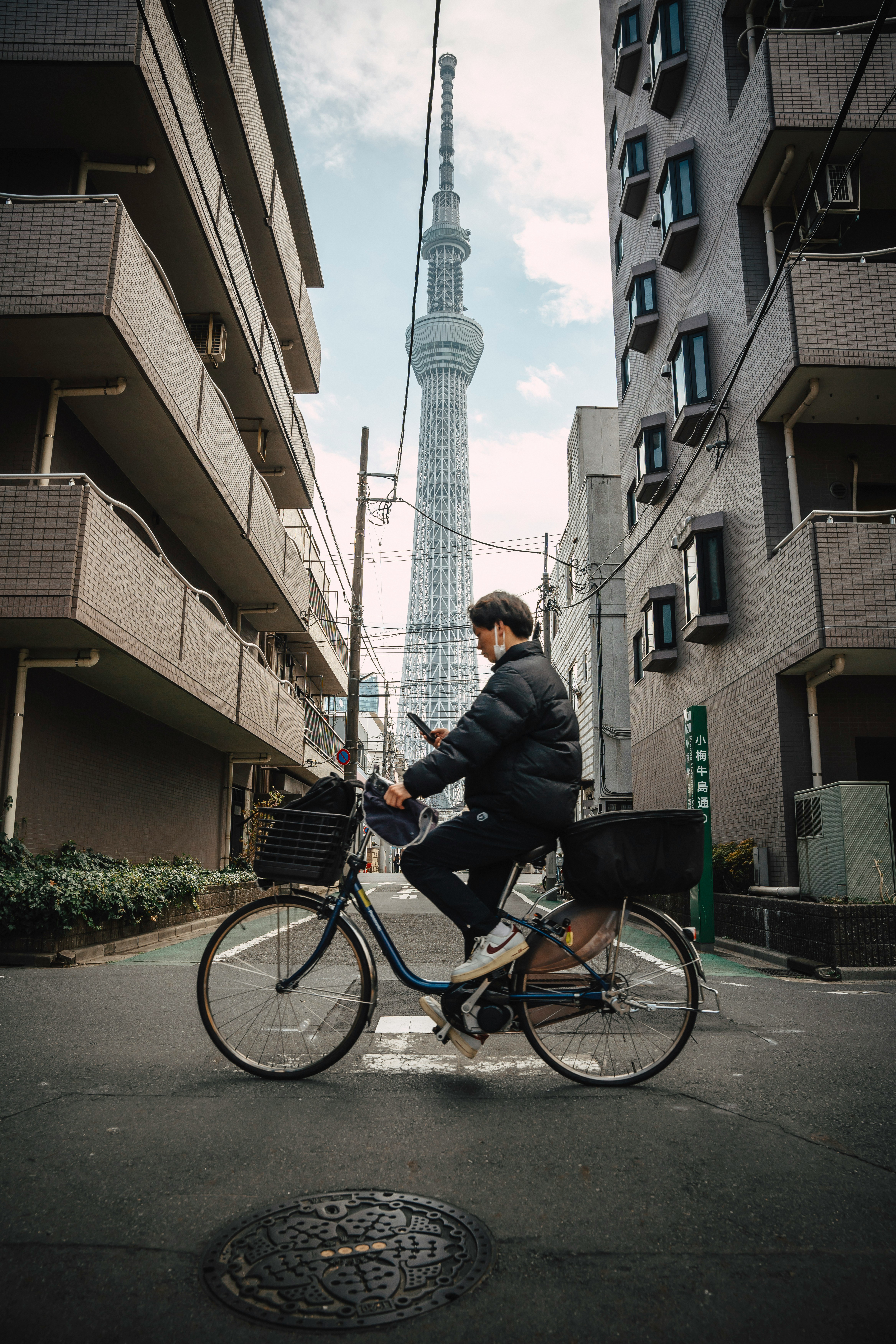 男子騎自行車環顧手機，望向東京晴空塔手機桌布高清圖片