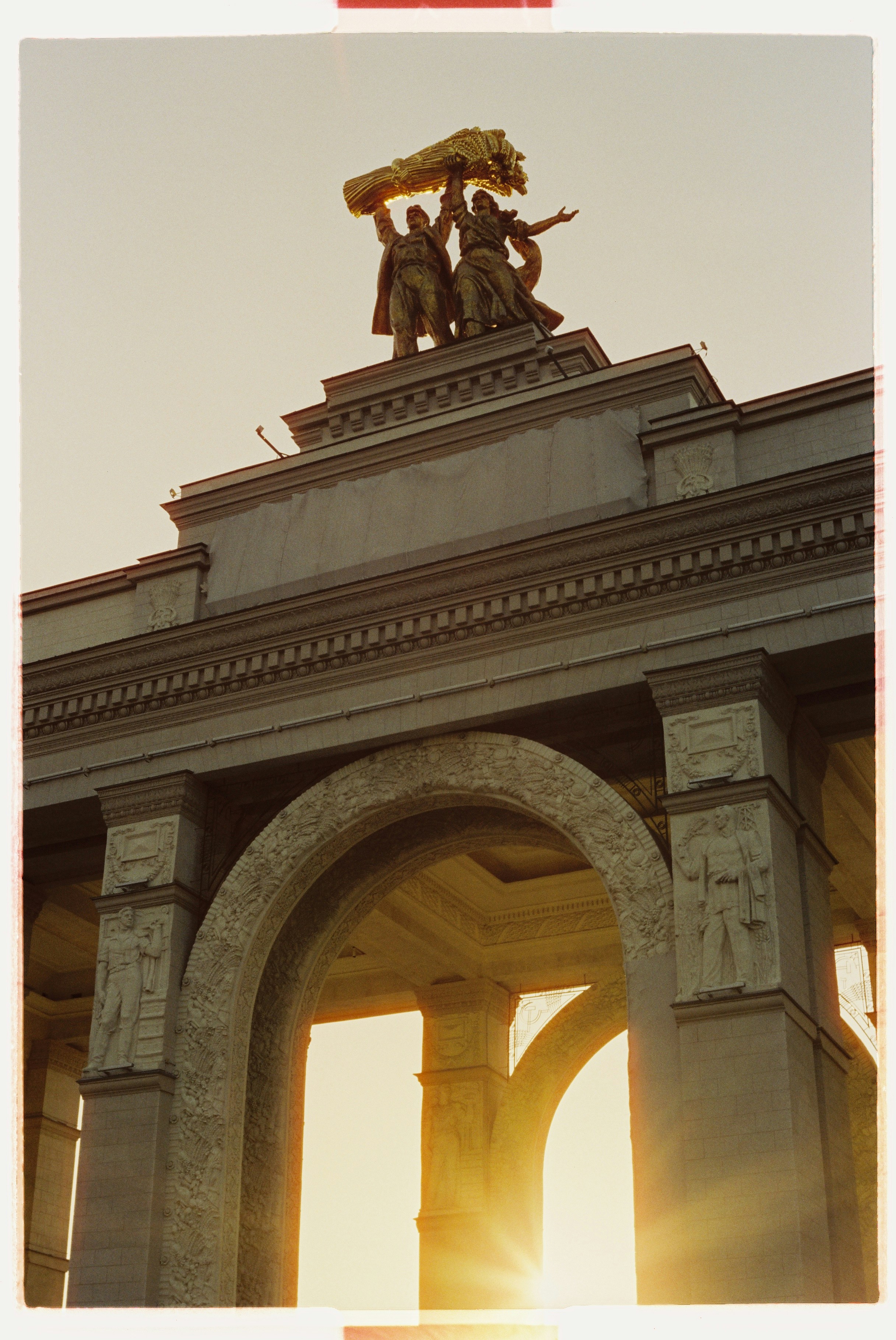 The Iconic Main Entrance Arch At VDNKh Illuminated By Warm Golden Hour Sunlight. Captured On 35mm Film With A Canon AE-1 Program. HD mobile wallpaper
