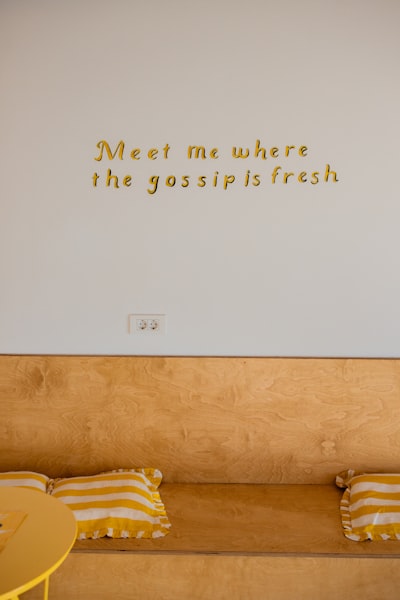 Gold Lettering On White Wall Above Wooden Bench wallpaper preview