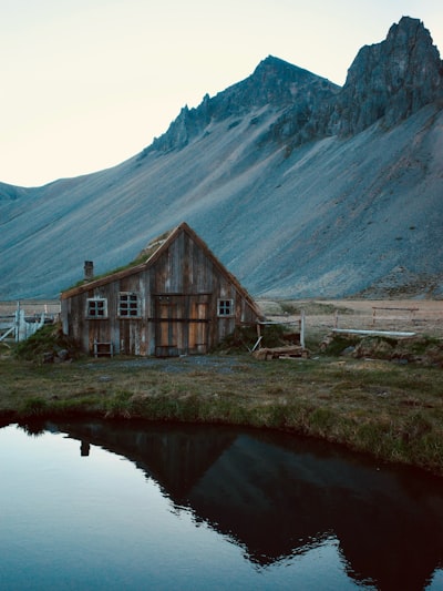 乡村木屋映照在水中的倒影，远处的山峰如画